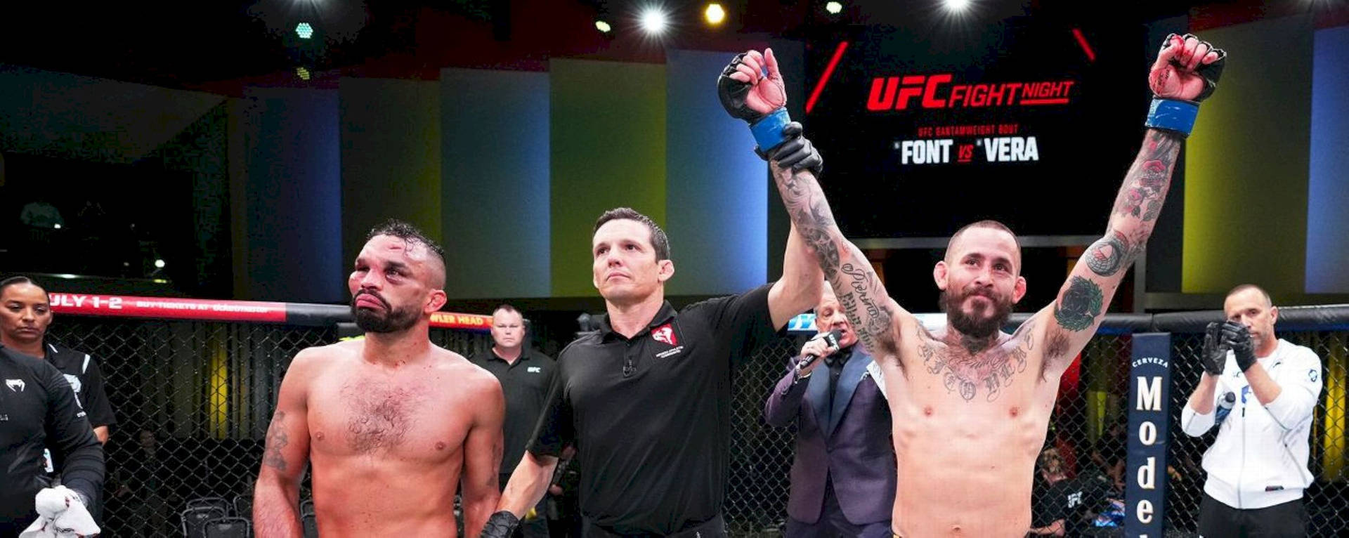 UFC拳手在八角籠中舉起拳頭慶祝勝利。
