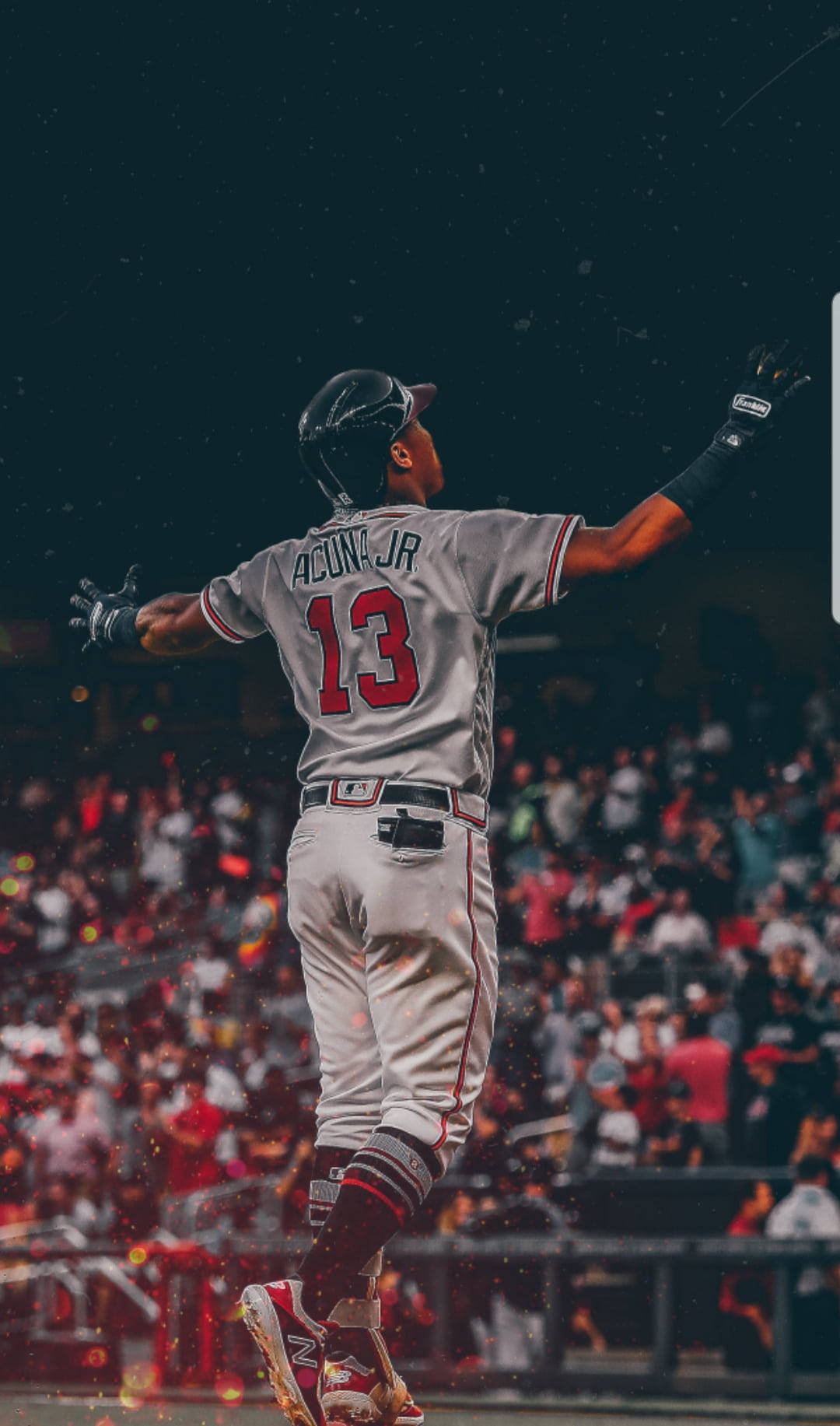 羅納德·阿庫納·小傑的勝利漫步 壁紙 — 棒球手阿庫尼亞Jr. 13號在球場燈光下高舉雙臂勝利跳躍，彩紙飄落。