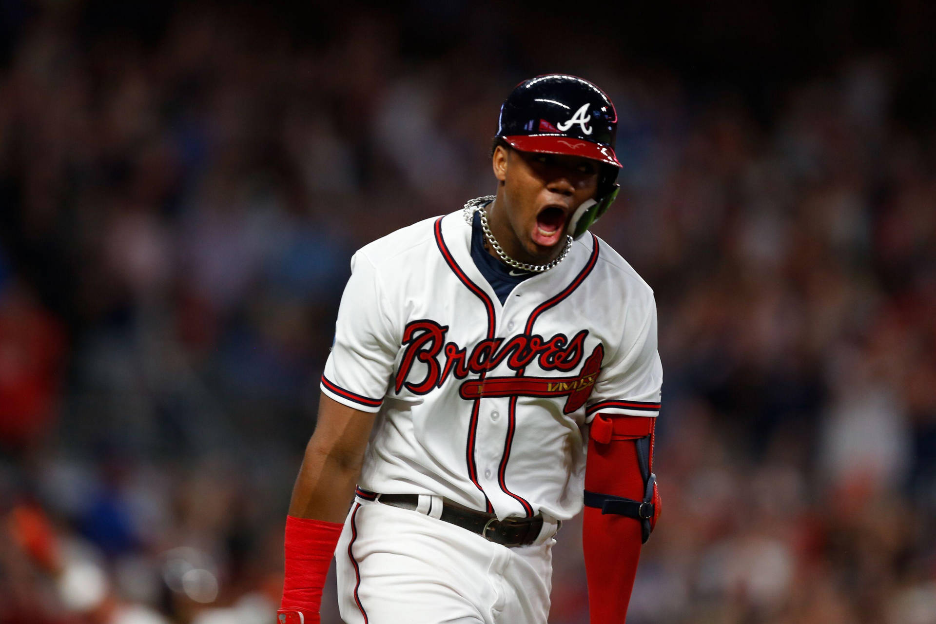 身穿Braves球衣的棒球手在夜間比賽慶祝勝利。