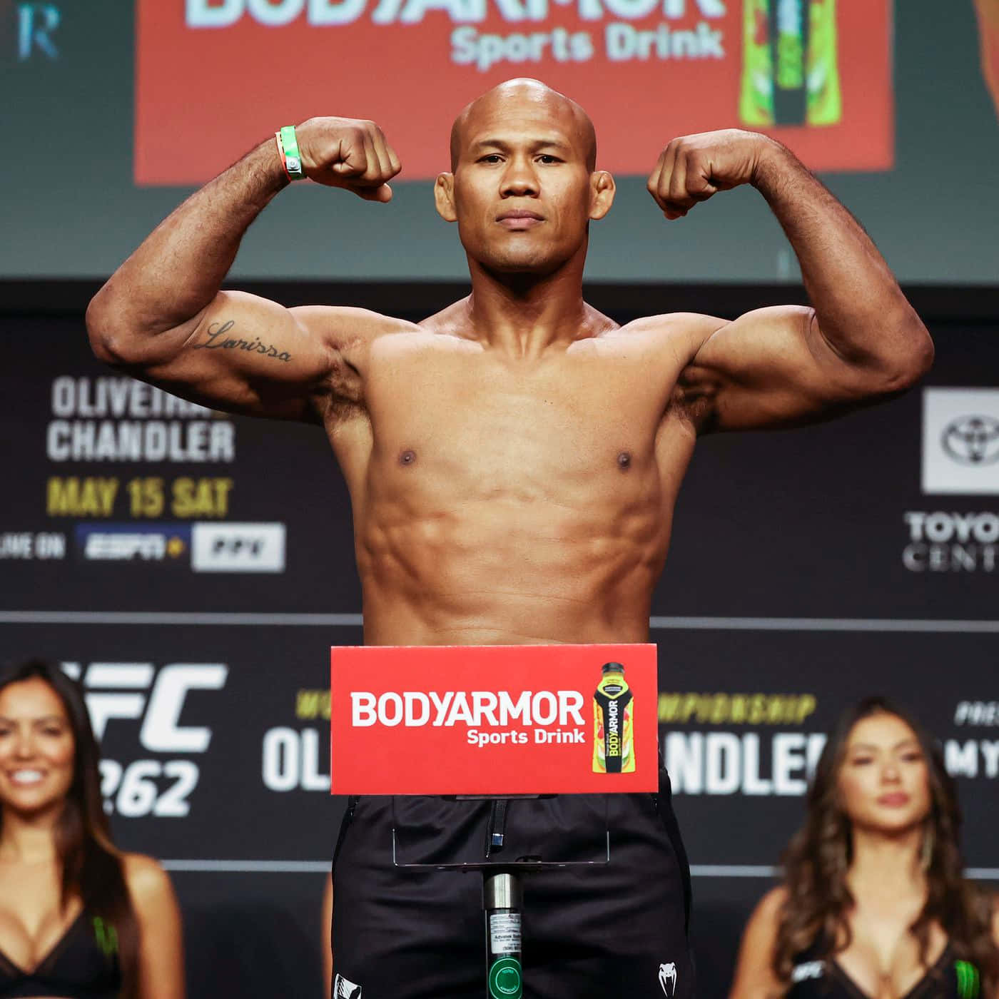 羅納爾多·蘇扎UFC 262肌肉展示 壁紙 — 一位肌肉發達的UFC拳手在稱重活動中，在體重磅上彎曲手臂，身後有贊助商橫幅。