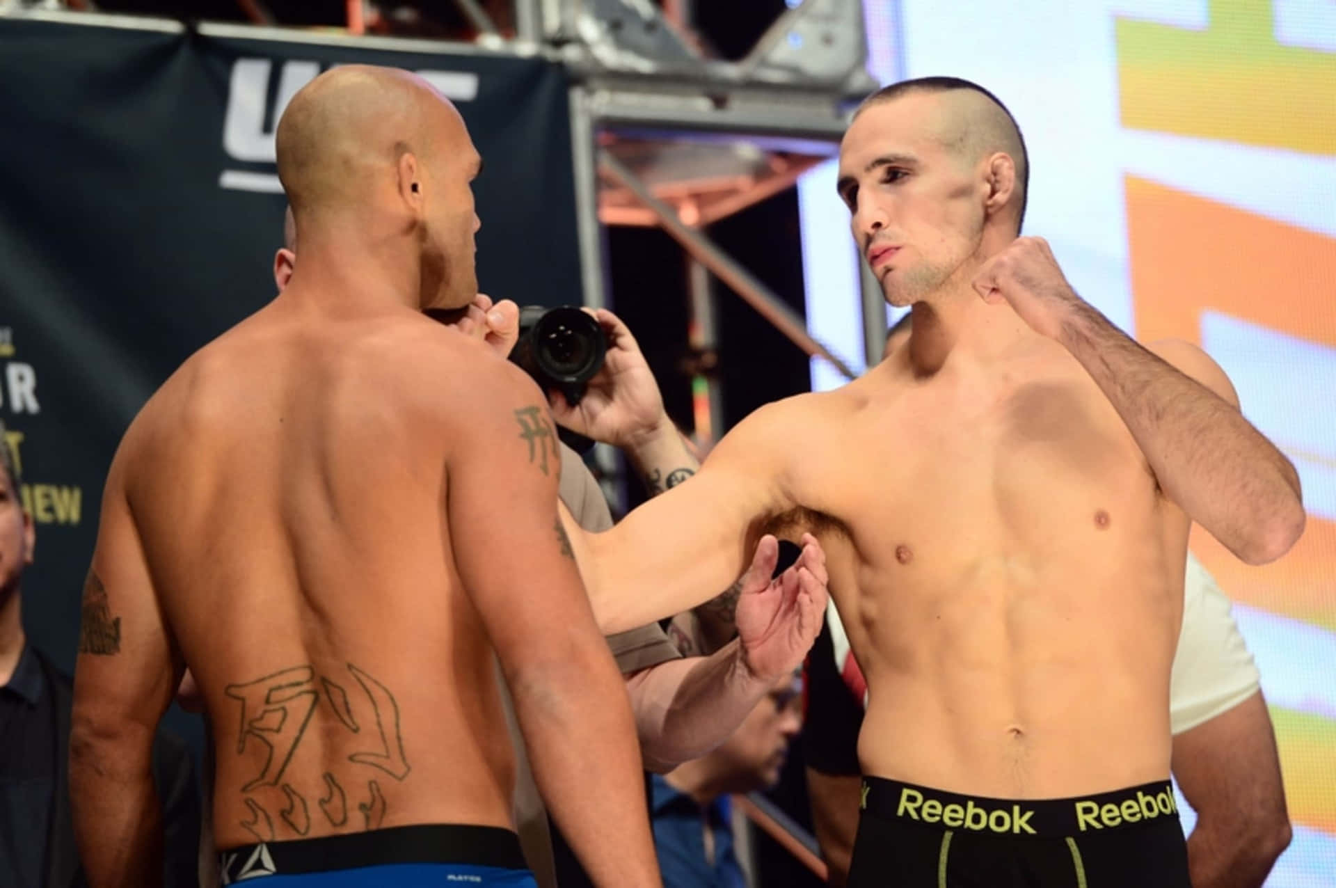 兩名赤裸上身的UFC拳手在稱重活動中互相凝視。