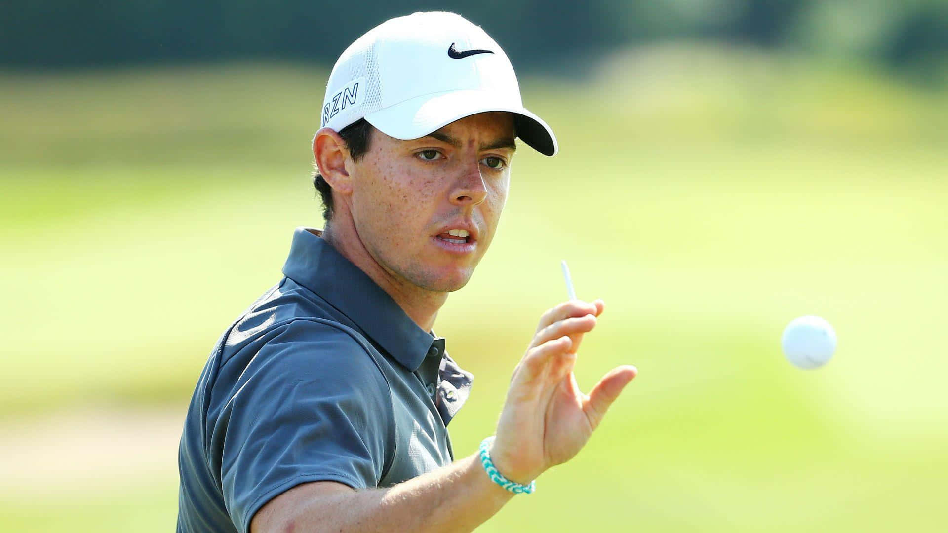 職業高爾夫球手Rory McIlroy在陽光明媚的高爾夫球場上揮桿。