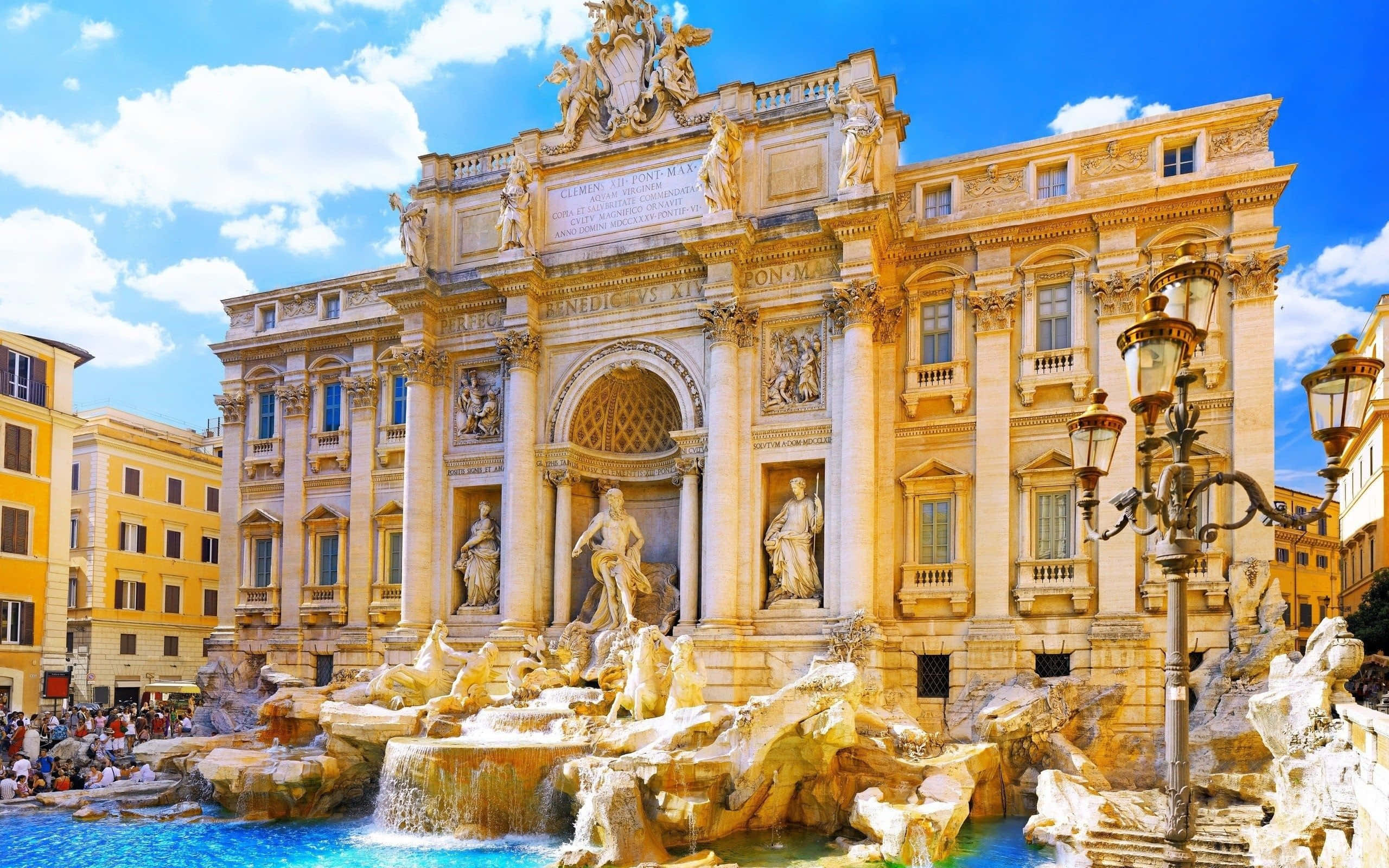 Rome 桌布 壁紙 — 羅馬宏偉的特雷維噴泉沐浴在明亮的陽光下，瀑布般的水流和華麗的雕塑在鮮豔的藍天下。