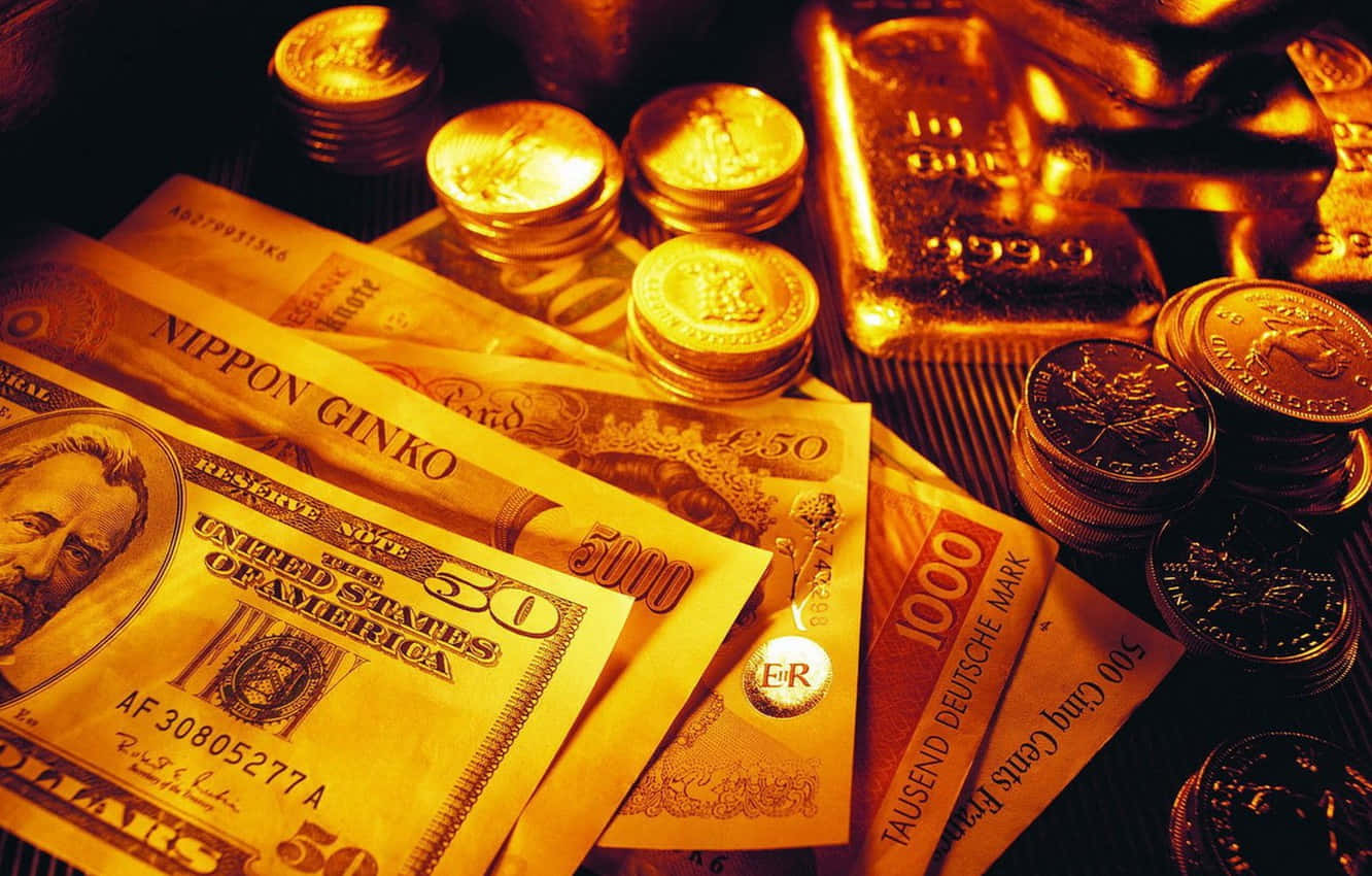 美元紙鈔與堆疊硬幣 壁紙 — 溫暖的金色光芒照亮了堆疊的國際貨幣以及閃閃發光的金幣和金條，呈現出奢華的展示。