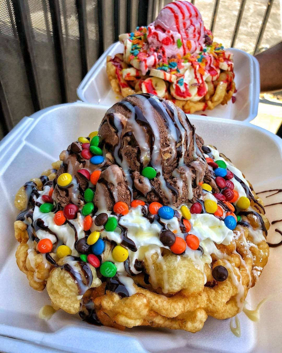 美味 funnel cake 壁紙 — 兩個高聳的窩夫筒，上面有雪糕、朱古力醬、忌廉和色彩繽紛的M&M's糖果。