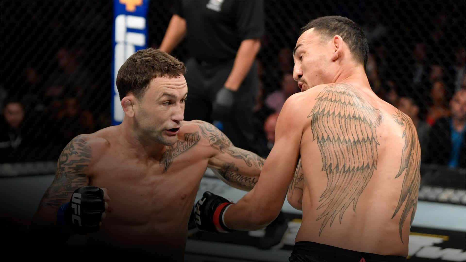 美國 UFC 冠軍弗蘭基·愛德華對戰馬克斯·霍洛威 壁紙 — 兩名紋身MMA拳手在UFC八角籠內激烈對峙，背景有觀眾。