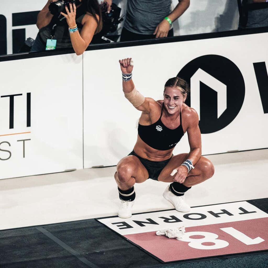 女性運動員舉起拳頭慶祝體育比賽勝利。