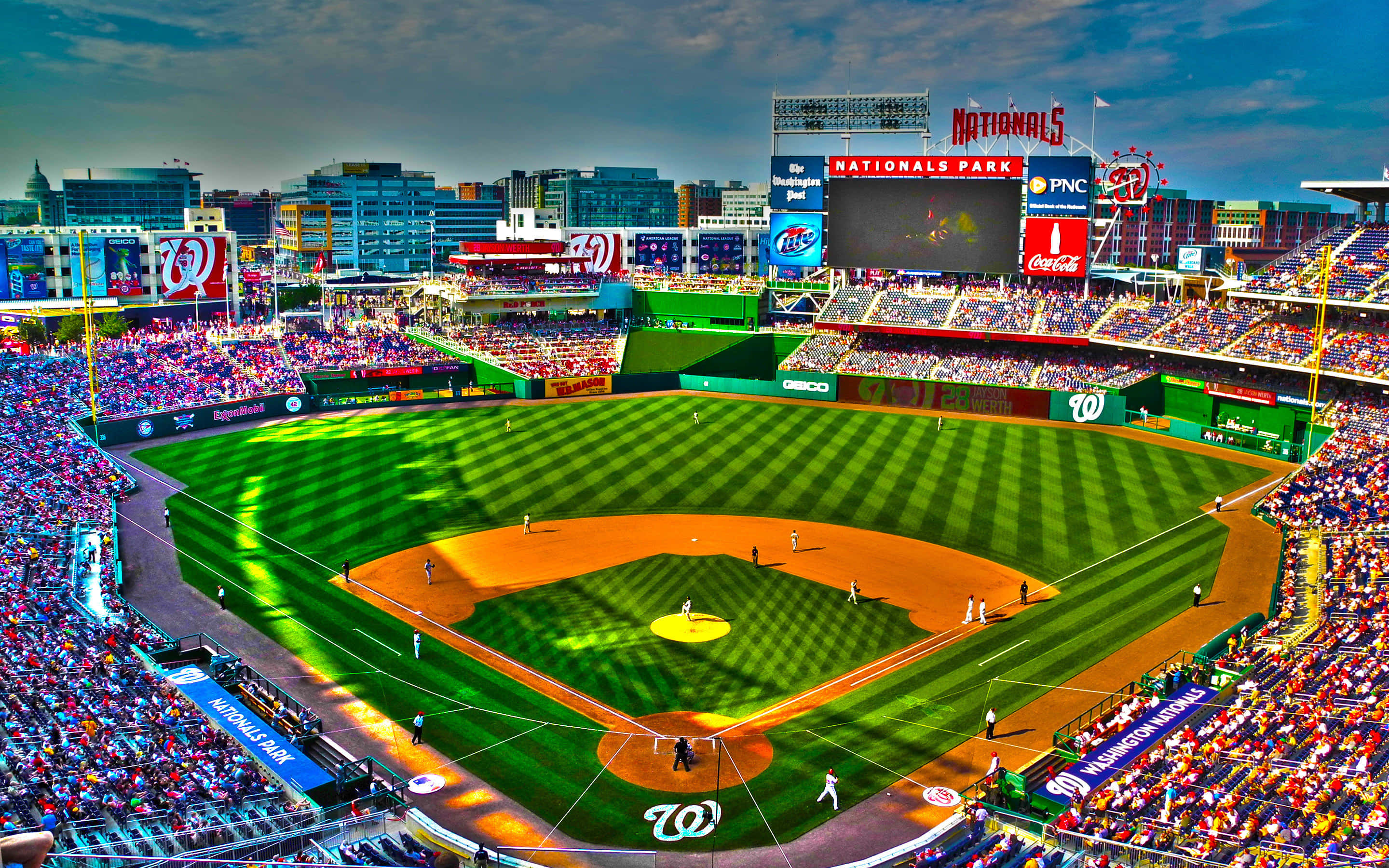 美國國民運動的完美場所 壁紙 — 在戲劇性的暮色天空下，Nationals Park 棒球場擠滿球迷的鳥瞰圖。