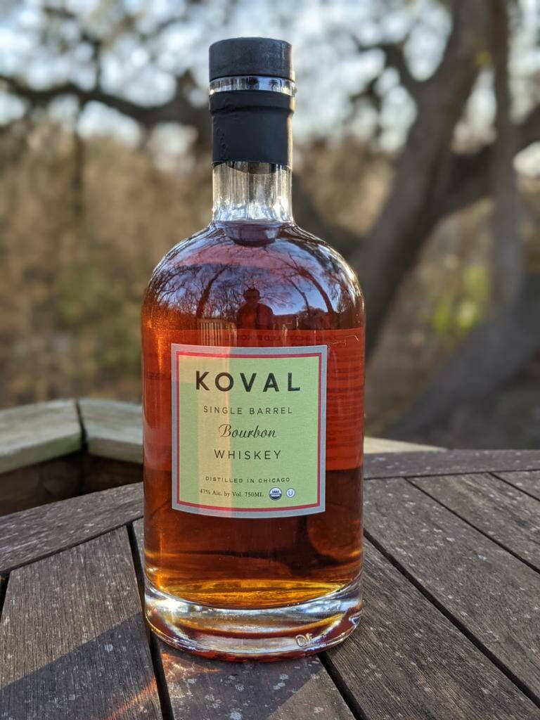 戶外木桌上的一瓶Koval波本威士忌。