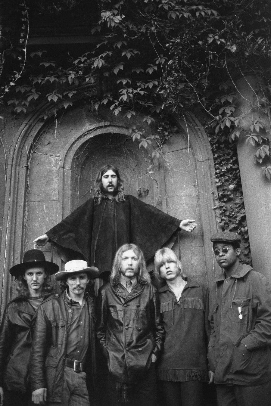 美國搖滾樂團 Allman Brothers 壁紙 — 一張黑白照片，六名身穿1970年代服裝的男子在常春藤覆蓋的石拱門前擺姿勢。
