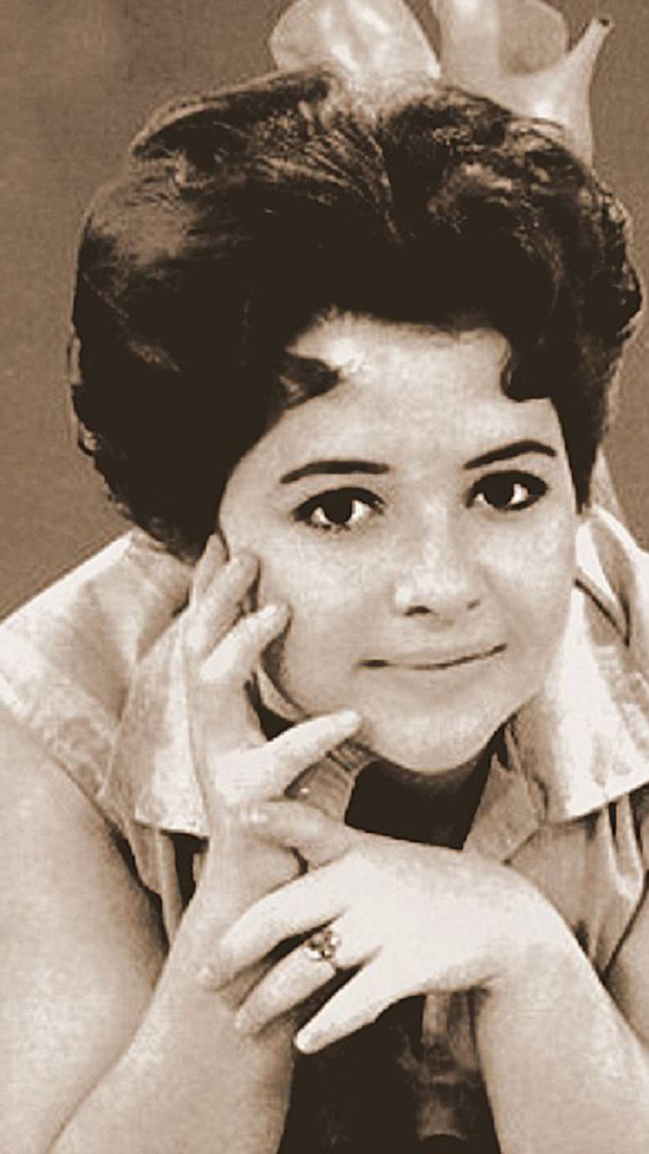美國歌手Brenda Lee《I'm Sorry》單曲封面 壁紙 — 一幅復古棕褐色調的肖像，一位深色頭髮、溫柔微笑的女性將下巴擱在手上。