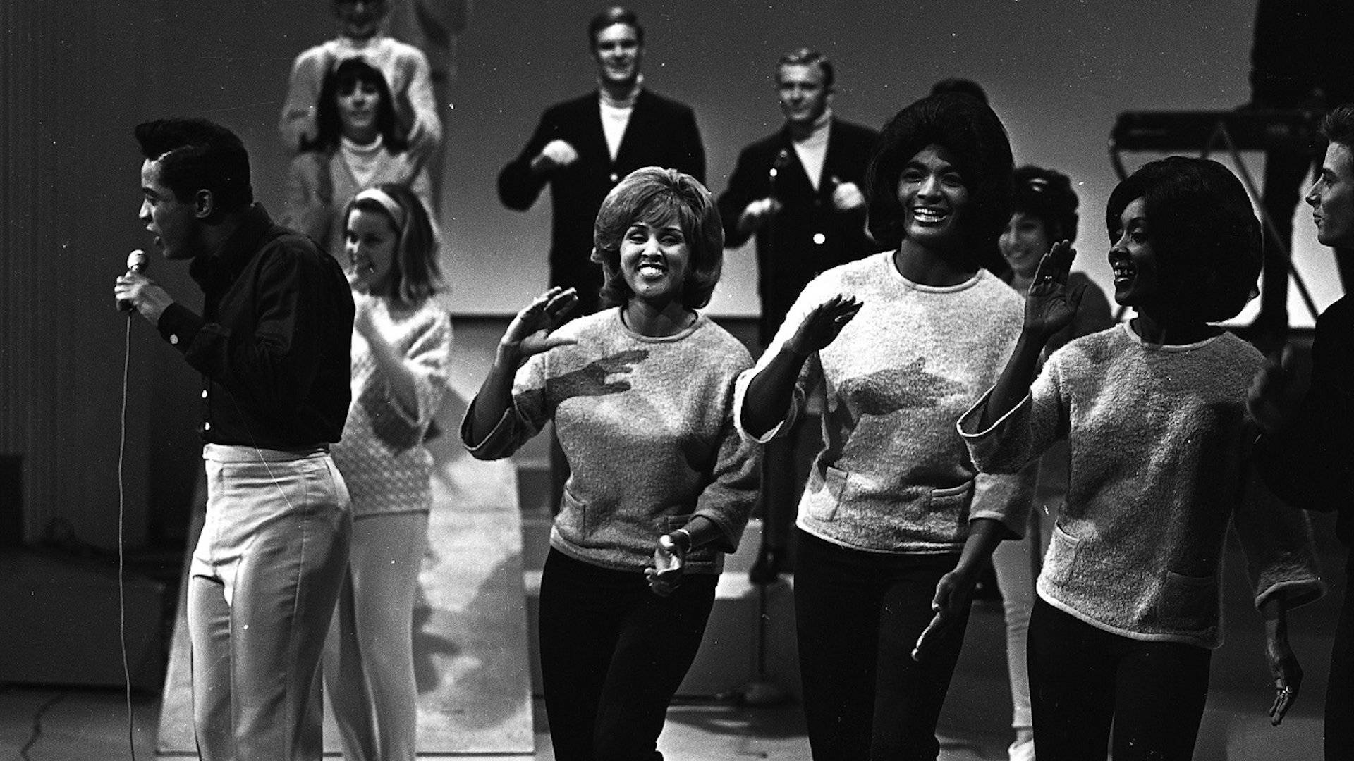 美國歌手Jackie Wilson、Fanita James與Darlene Love的懷舊黑白影像 壁紙 — 一張1960年代音樂團體在舞台上表演的黑白照片，展現歡樂表情和動態姿勢。