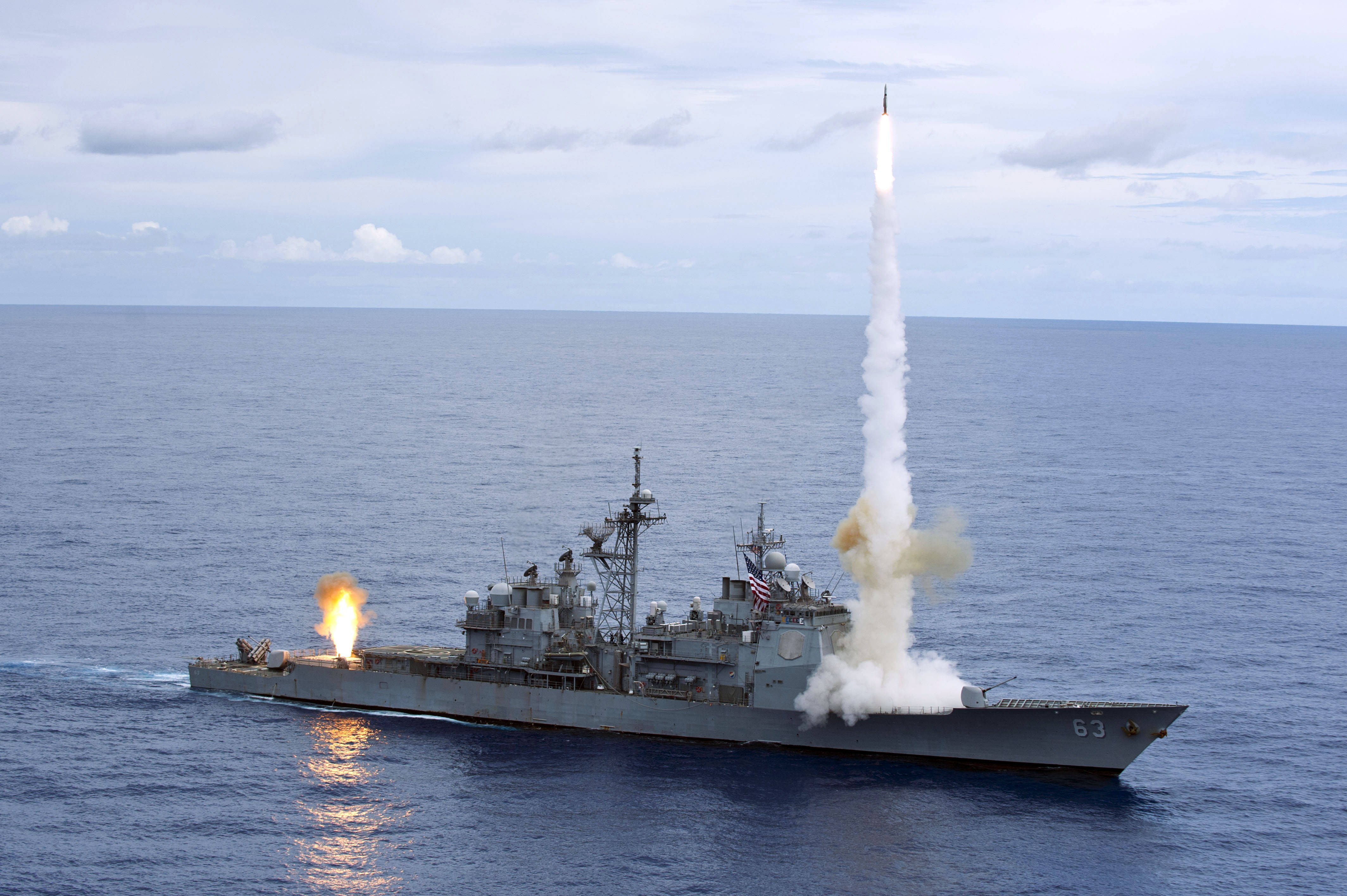 美國海軍艦艇發射導彈 壁紙 — 一艘灰色軍艦在陰天嘅開放海洋上空發射導彈。