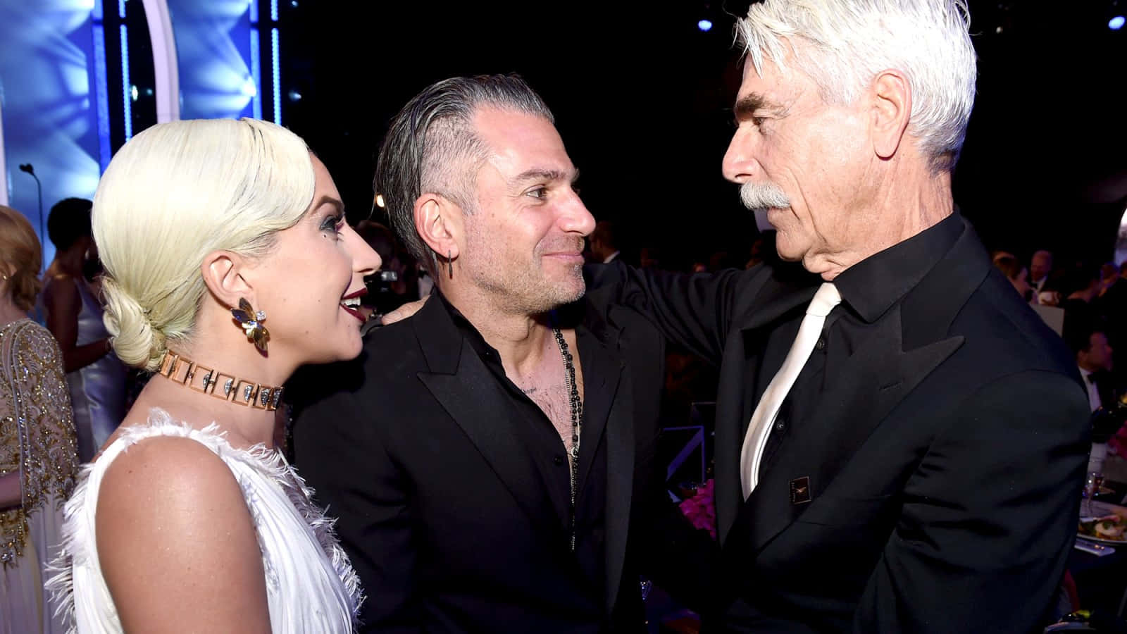 Gaga 和 Tom Hanks 在一個正式的頒獎活動中微笑聊天。