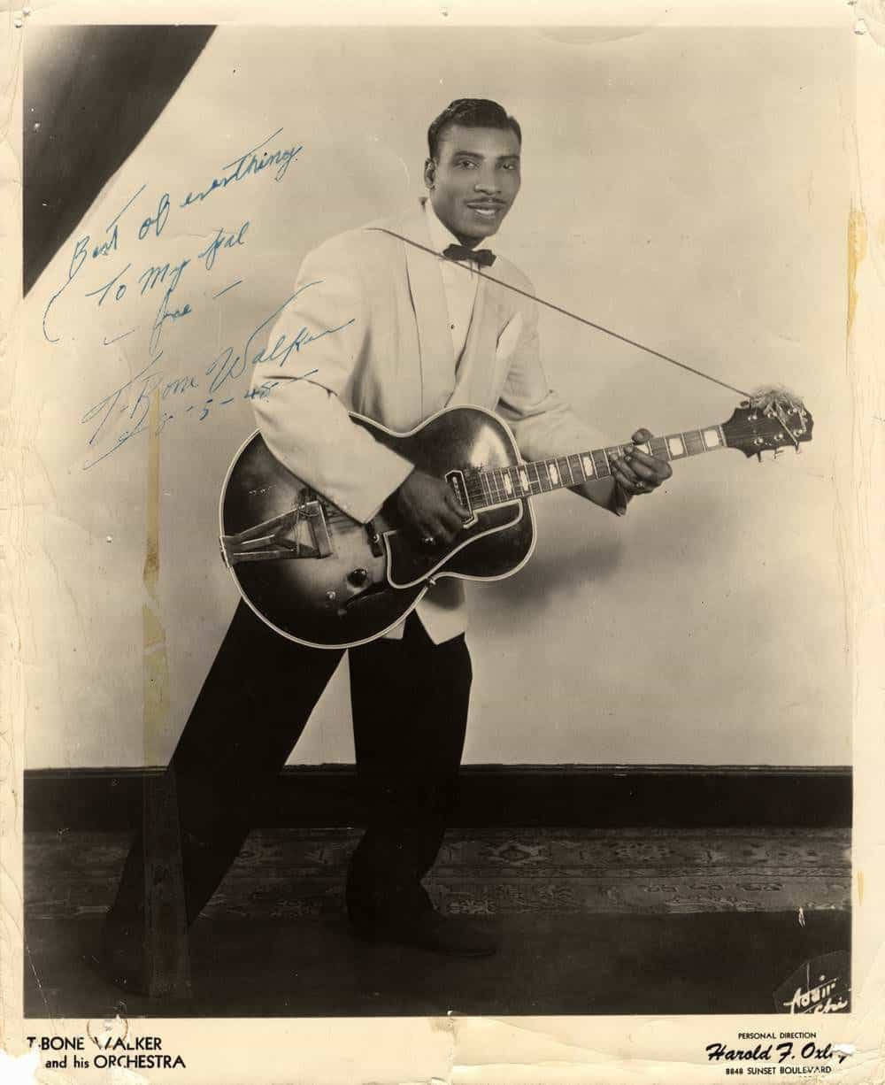 T Bone Walker 在附有手寫說明的復古攝影棚照片中手持結他。