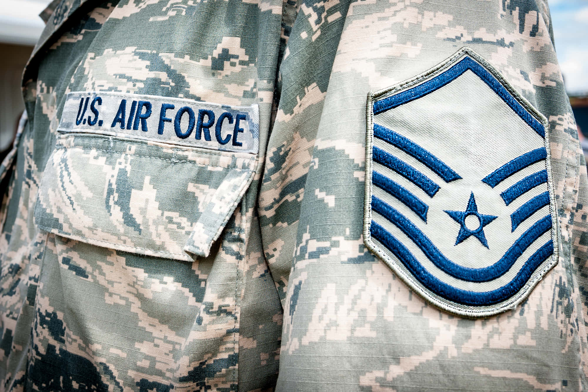 空軍 桌布 壁紙 — 美國空軍制服近距離特寫，顯示數碼迷彩布料上的軍階徽章及「U.S. AIR FORCE」臂章。
