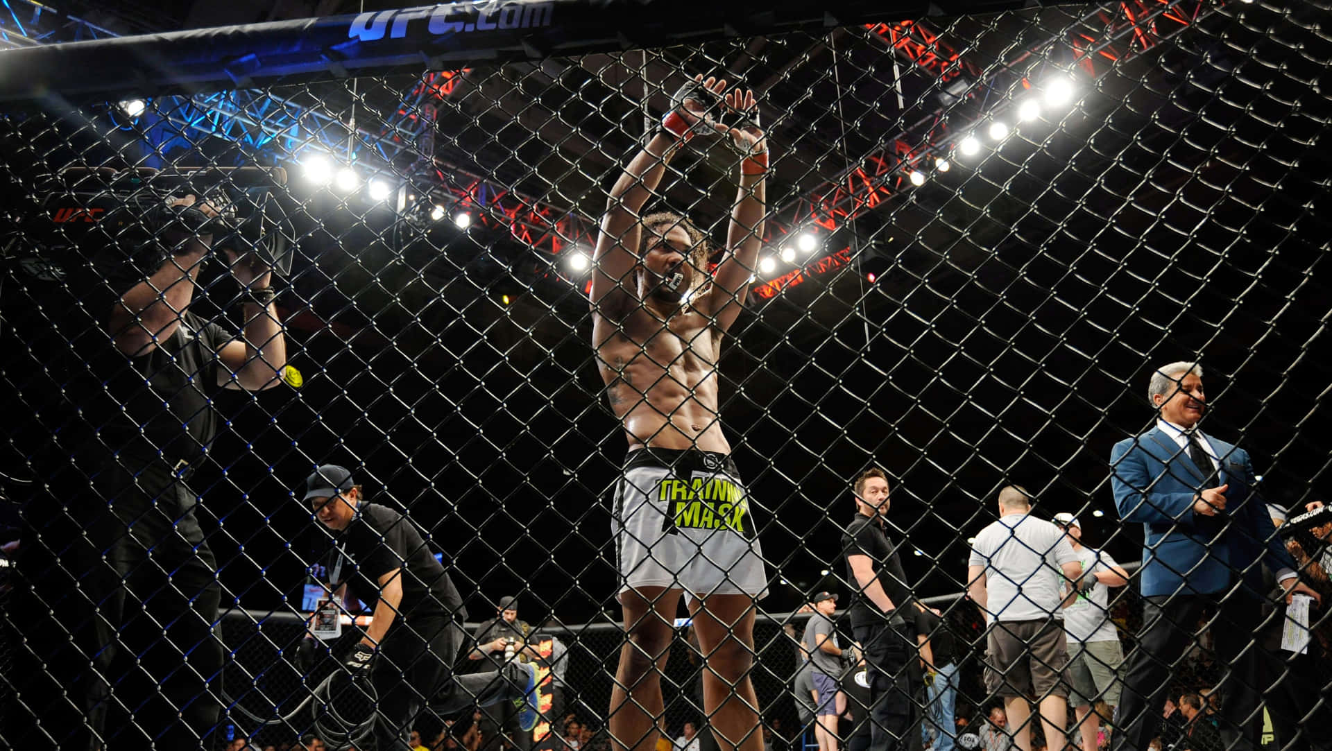UFC拳手在八角籠內舉起雙臂慶祝勝利。