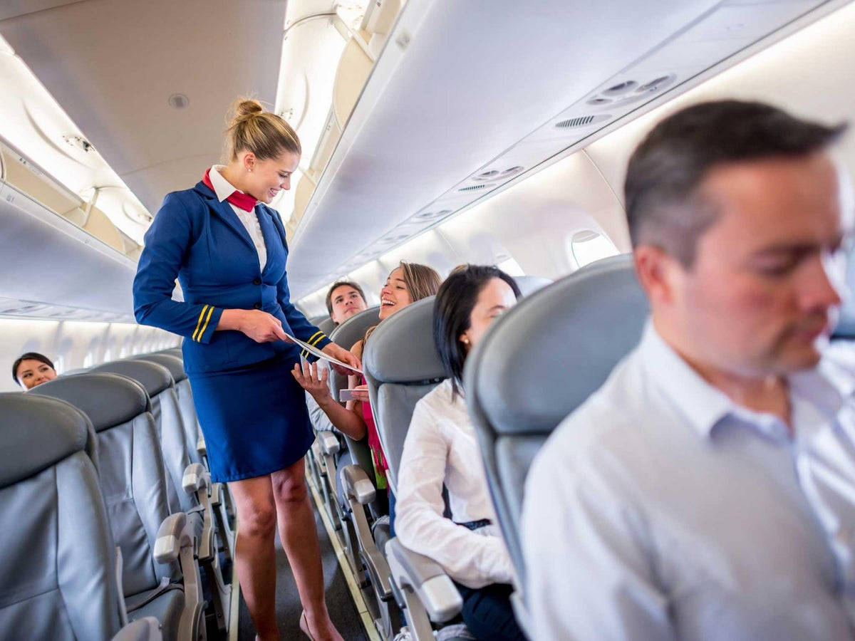 空服員在飛機上為乘客提供服務。