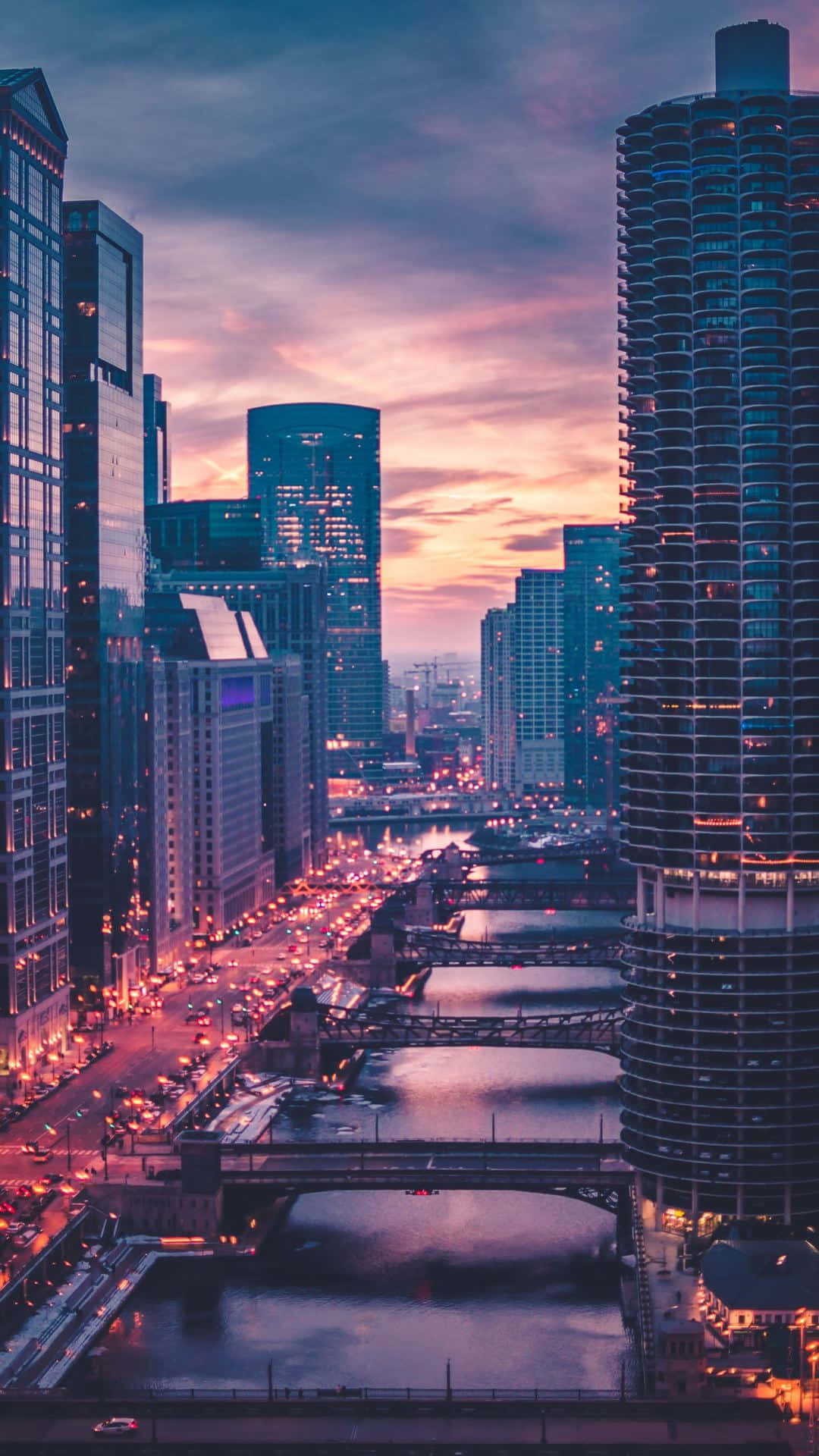 黃昏時分的市中心天際線，發光的建築物和下方的河流。