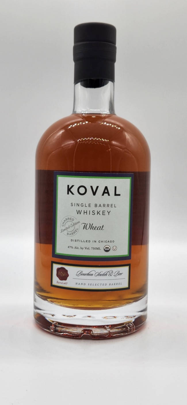 一瓶Koval Single Barrel Wheat Whiskey，琥珀色液體和黑色瓶蓋。