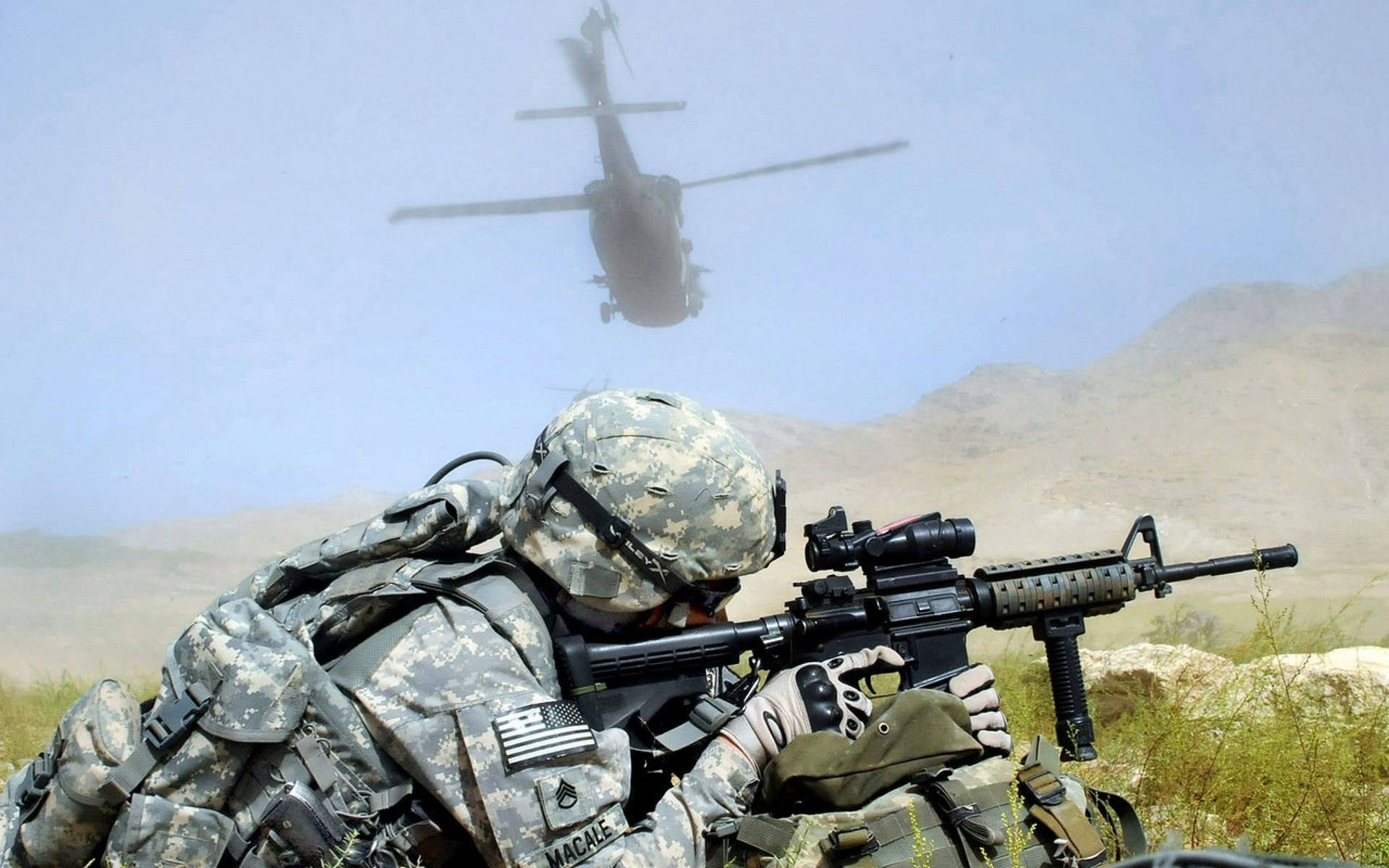 士兵瞄準步槍，直升機在沙漠山脈上空飛行。