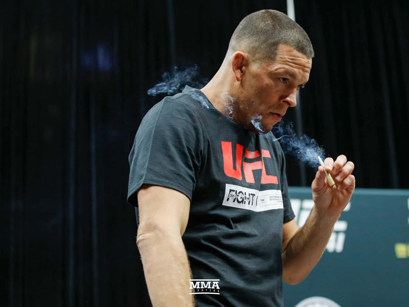 MMA拳手在健身房手持香煙呼出煙霧。