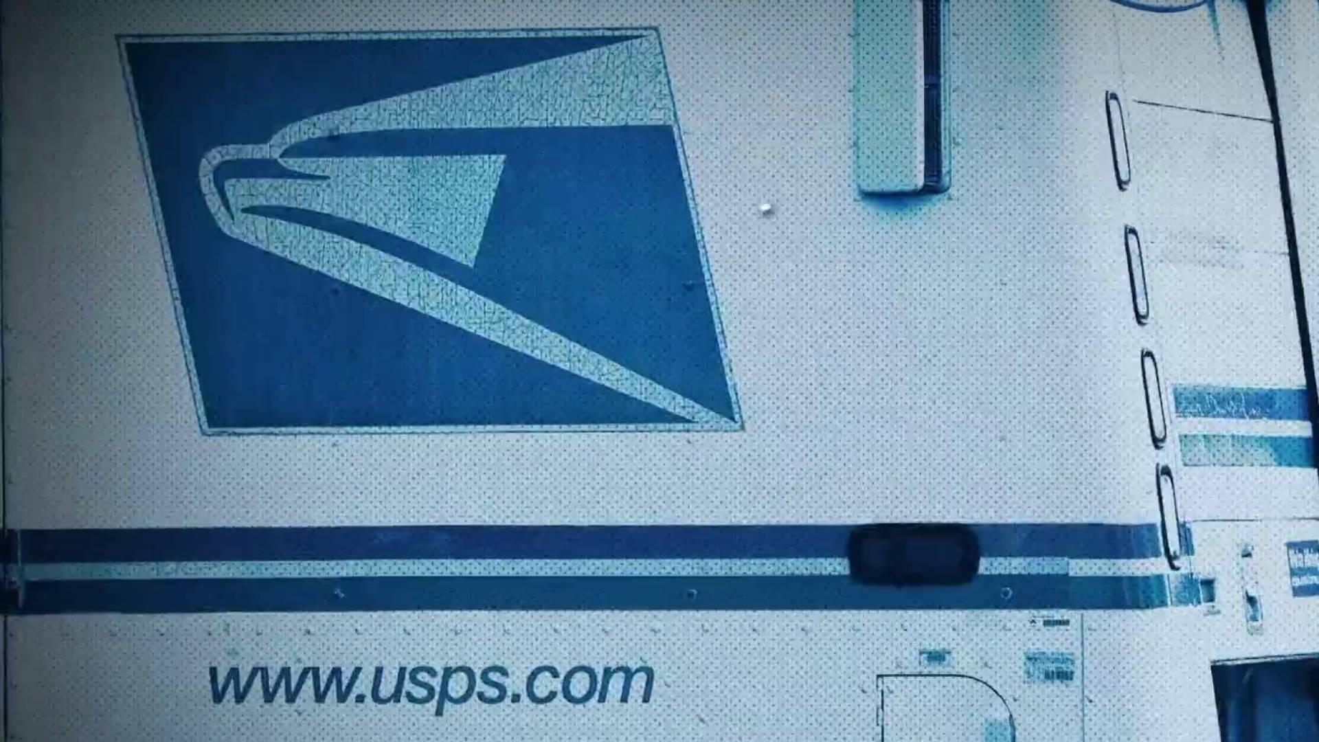 帶有藍色鷹標誌和網站文字的 USPS 送貨車