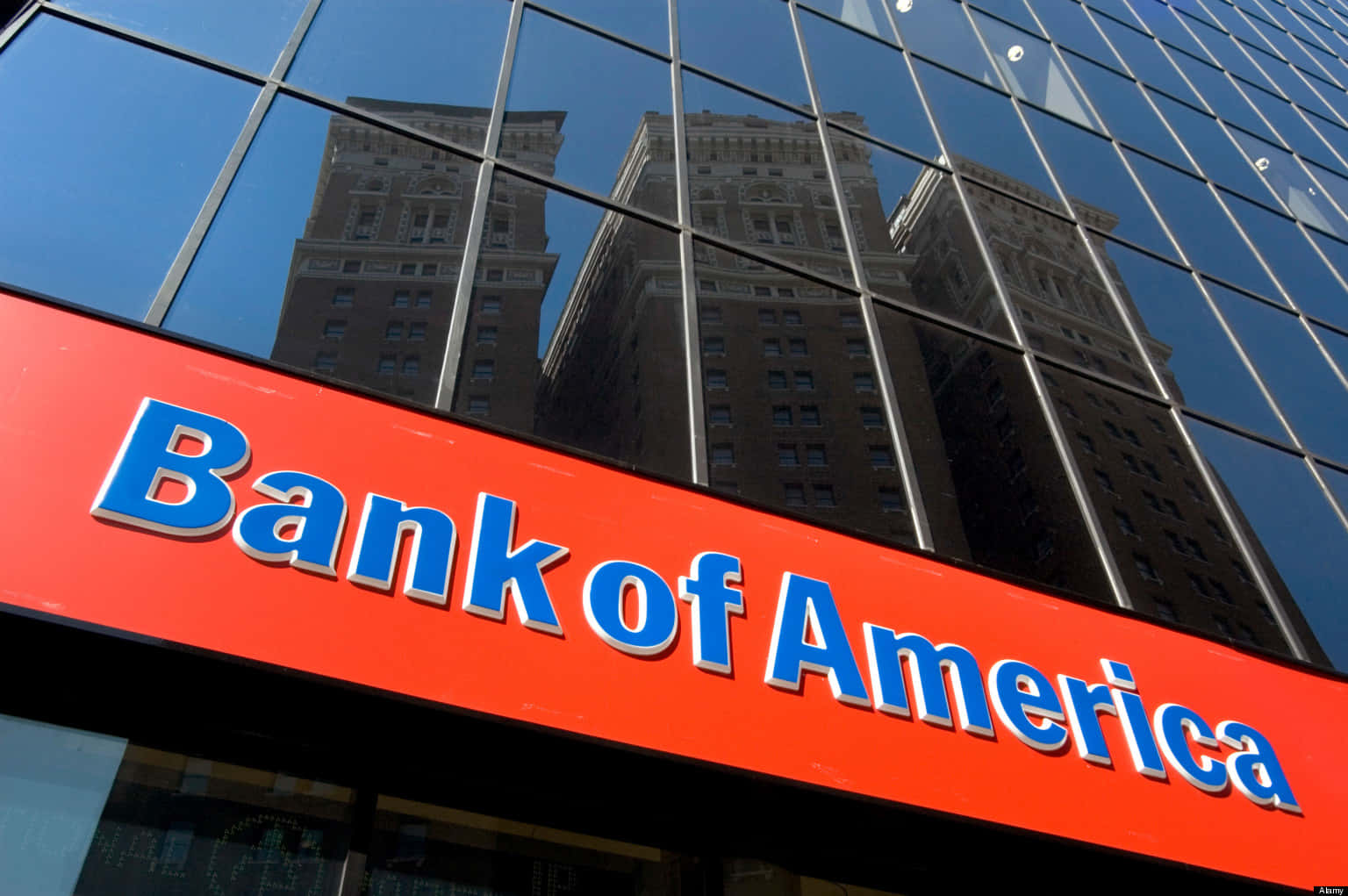 玻璃建築上的 Bank of America 標誌，帶有舊摩天大樓的倒影。