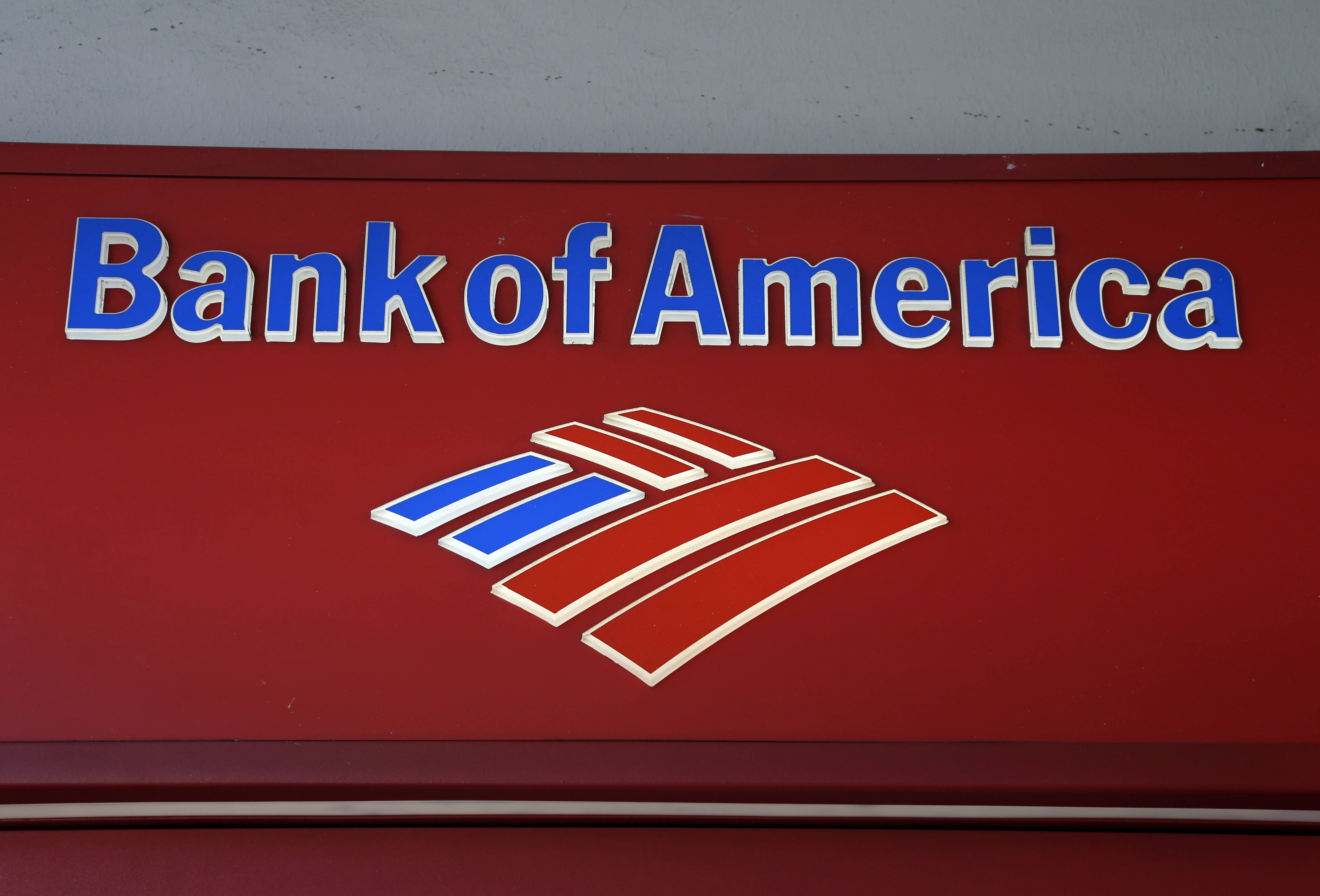 美國銀行紅色亞克力標誌 壁紙 — 特寫一個紅色嘅Bank of America標誌，上面有藍色同白色嘅字體同標誌，背景係普通牆壁。