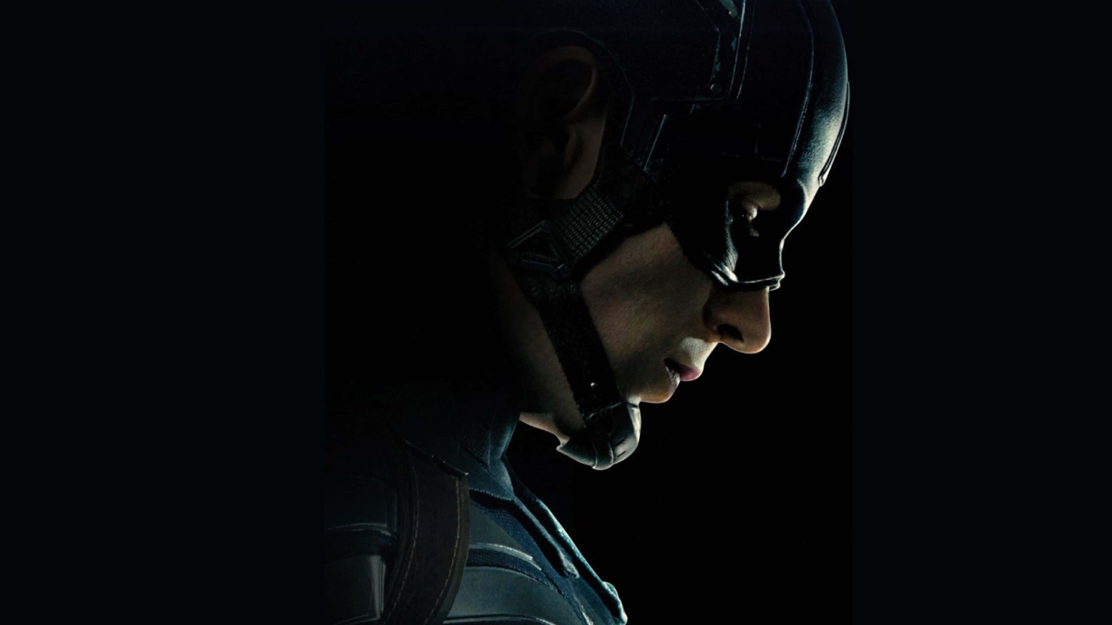 4K Captain America 桌布 壁紙 — 美國隊長側面輪廓的戲劇性特寫，背景為黑色，單一側光突顯他堅定的表情和頭盔。