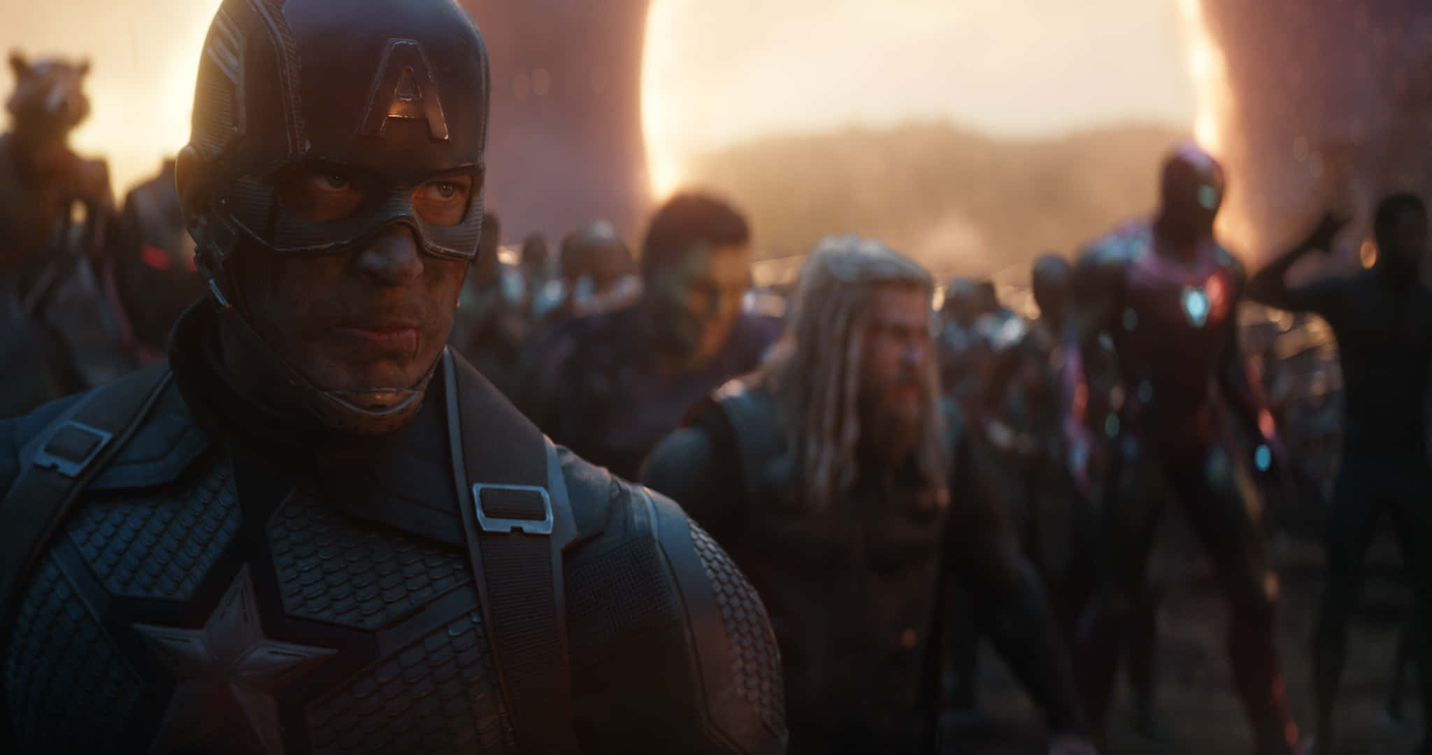 Mcu Characters 桌布 壁紙 — 美國隊長堅定地站在前景，身後有復仇者聯盟盟友，背景是熾熱的夕陽戰場。