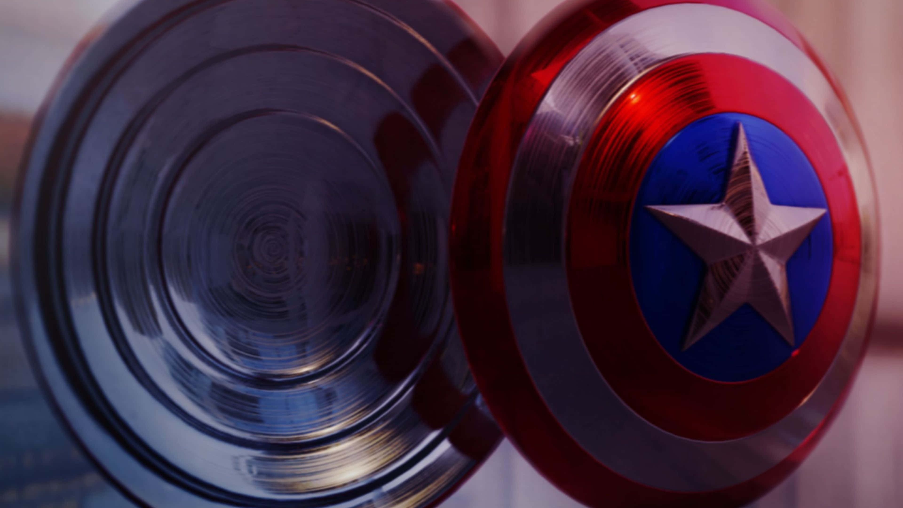 4K Captain America 桌布 壁紙 — 美國隊長標誌性紅白藍盾牌的特寫，帶有銀色星星及其金屬背面反射光線。