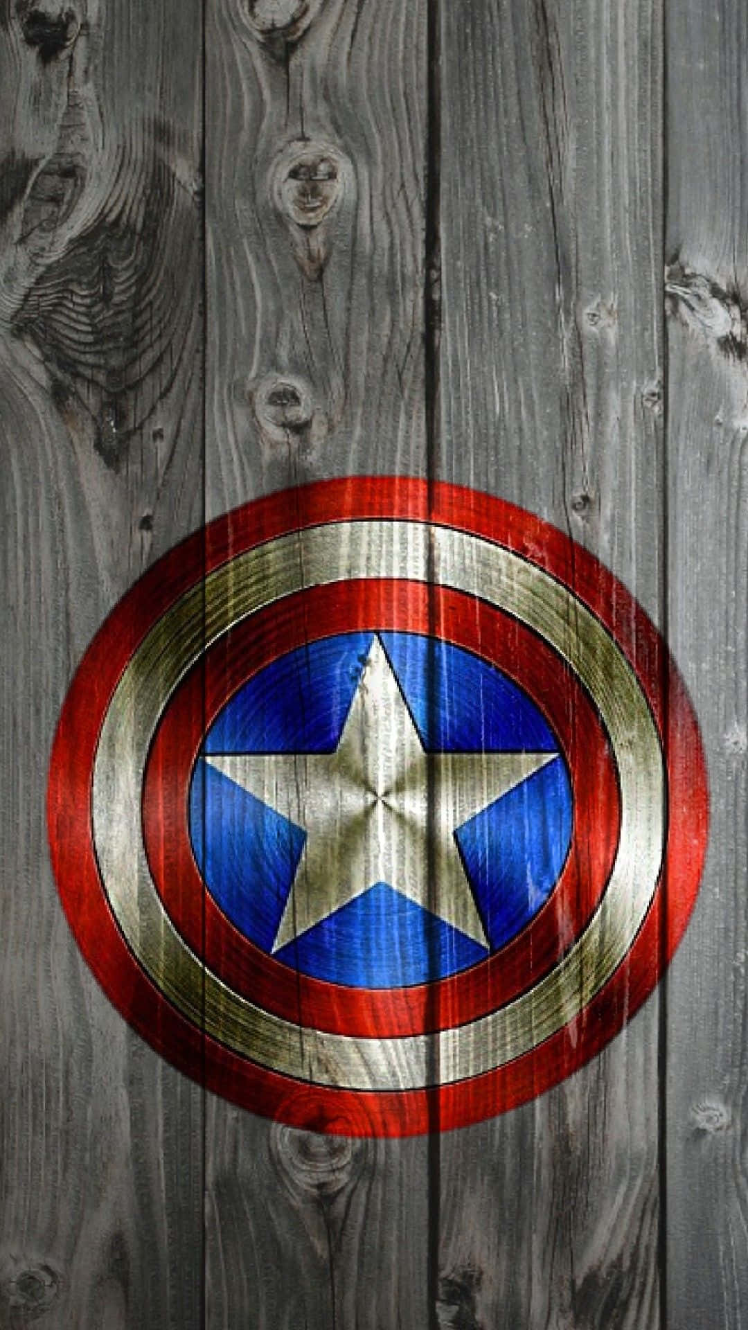 Best Captain America 桌布 壁紙 — 美國隊長的標誌性盾牌放在風化的灰色木板上，木紋和節疤清晰可見。