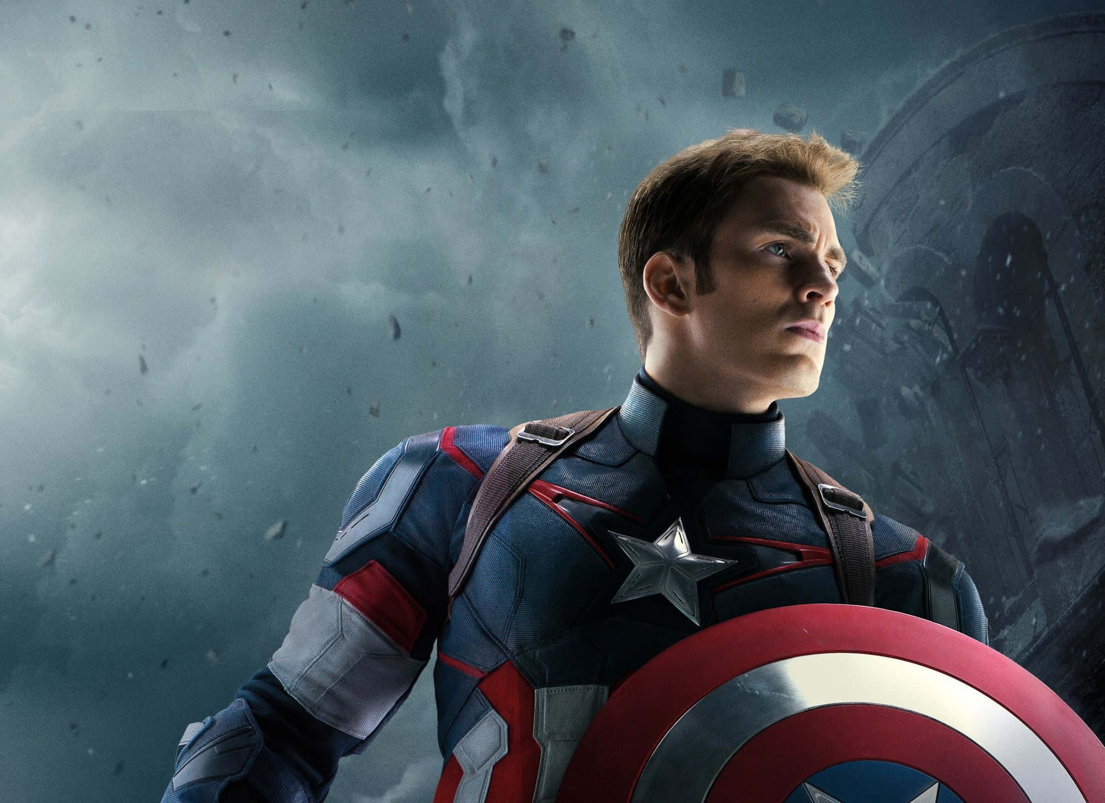 Best Captain America 桌布 壁紙 — 美國隊長身穿標誌性的紅白藍戰衣，手持圓形盾牌，在風暴肆虐的戰場背景下屹立不倒。