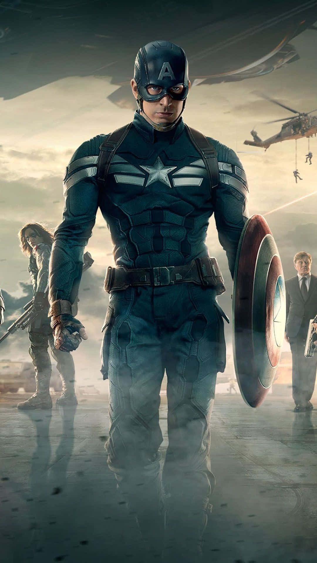 Best Captain America 桌布 壁紙 — 美國隊長身穿標誌性的藍色戰衣，堅定地舉著盾牌，而盟友們在煙霧瀰漫的戰區準備戰鬥。