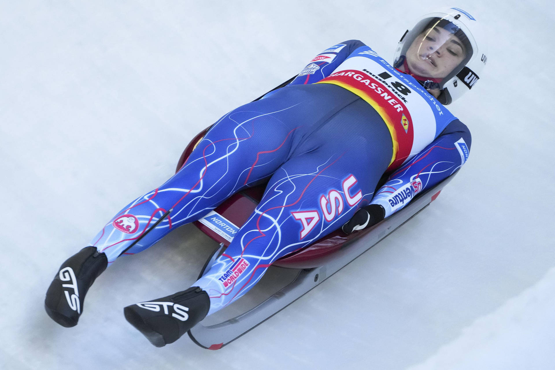 藍色服裝的雪橇運動員在冰道上