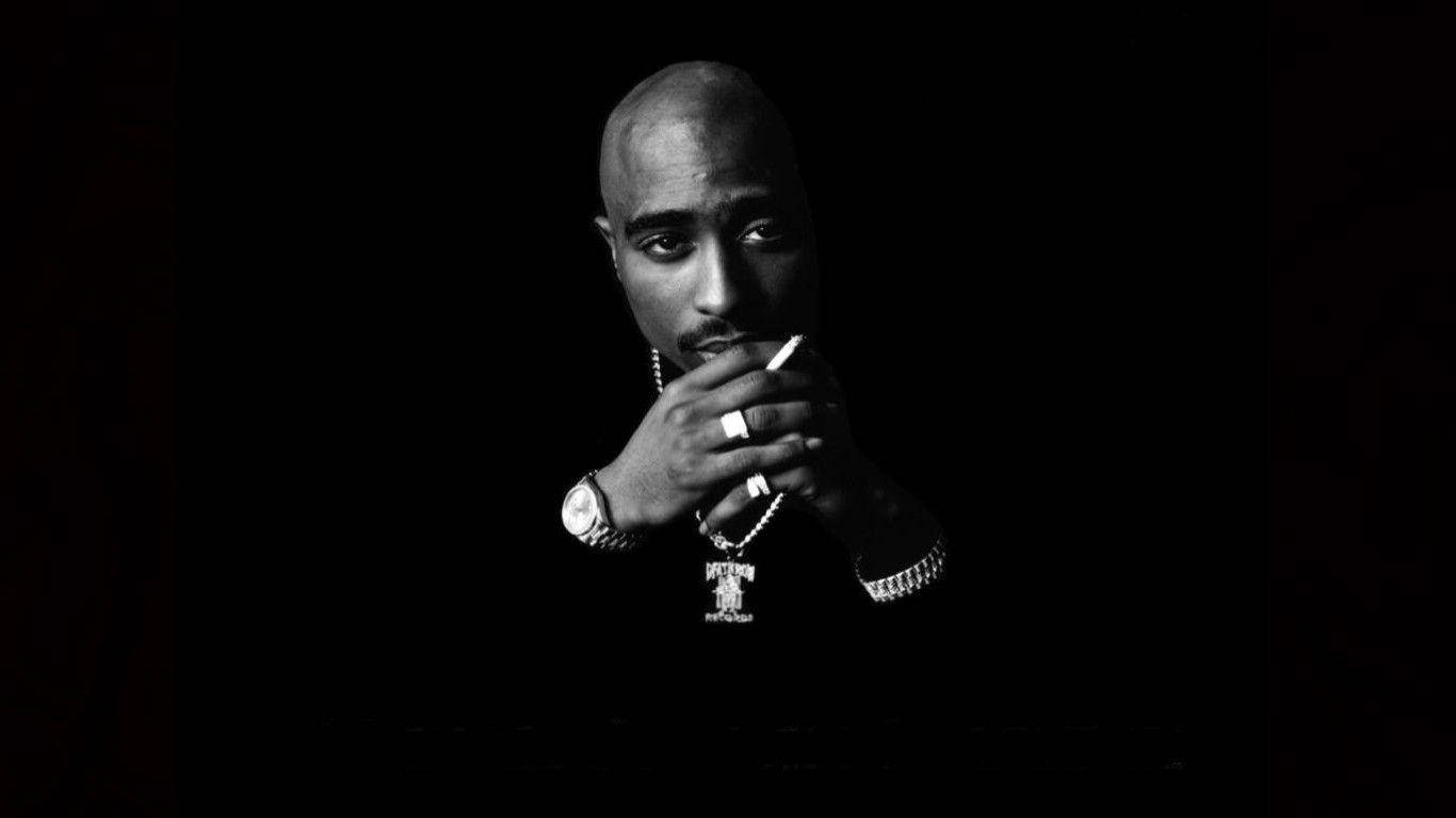 Tupac Shakur 在黑白工作室肖像中手持香煙。