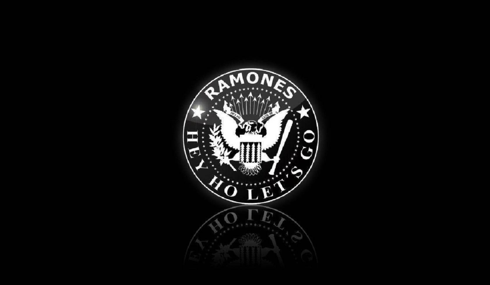 發光的 Ramones 標誌，帶有鷹和星星，在黑色背景上帶有倒影。