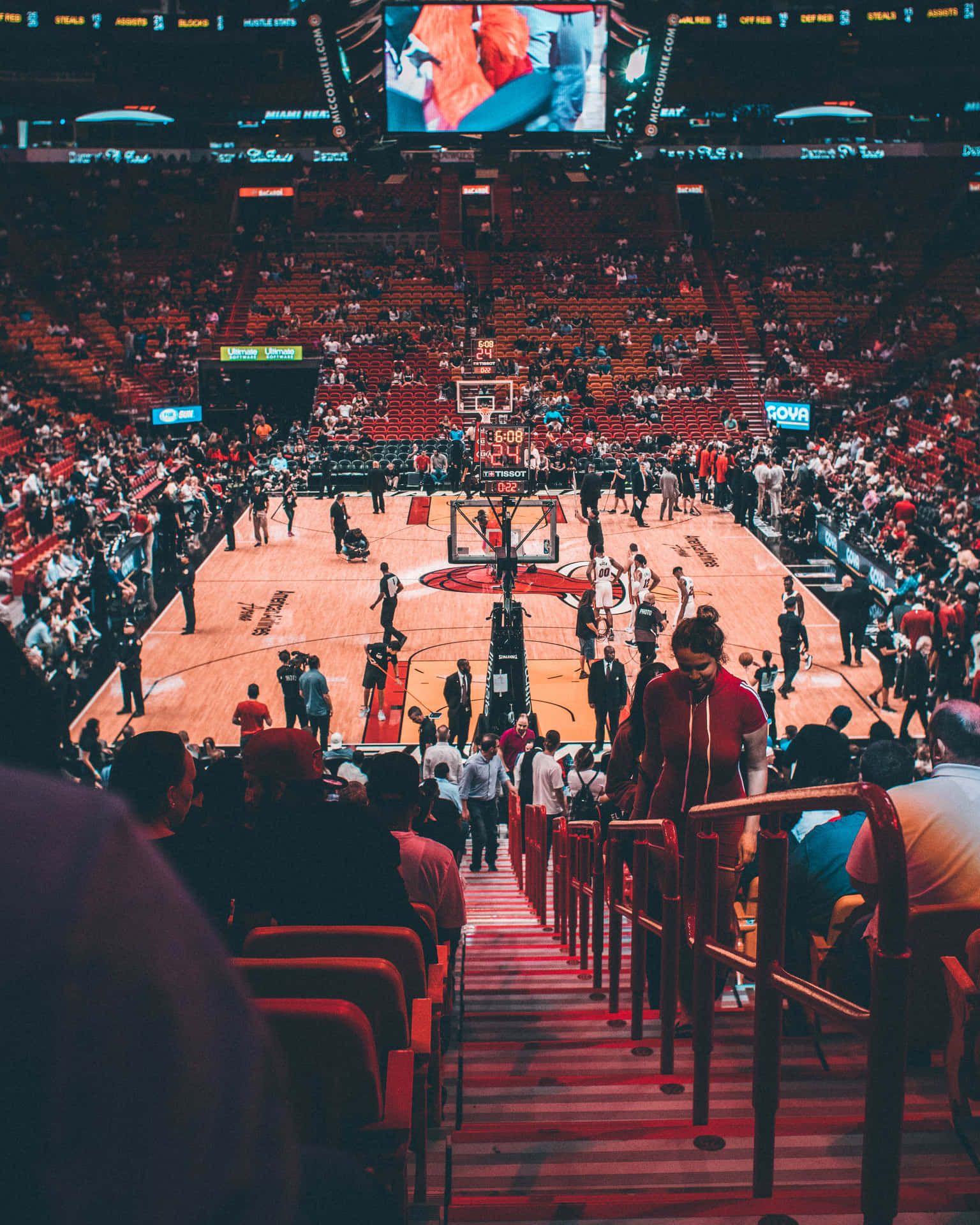 美學 NBA 籃球場館 壁紙 — 從高角度拍攝的擁擠籃球場，球員和工作人員在明亮的燈光下在場上。
