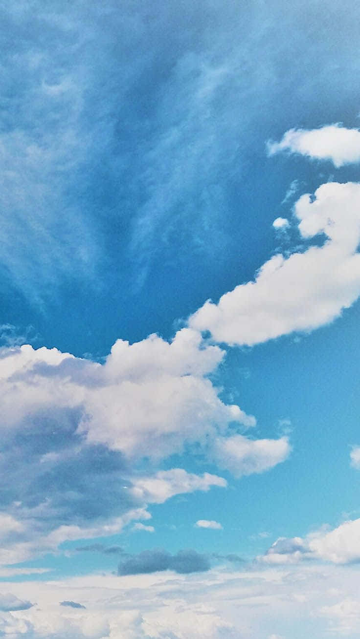 藍天，蓬鬆白雲在明亮白天的地平線上飄移。