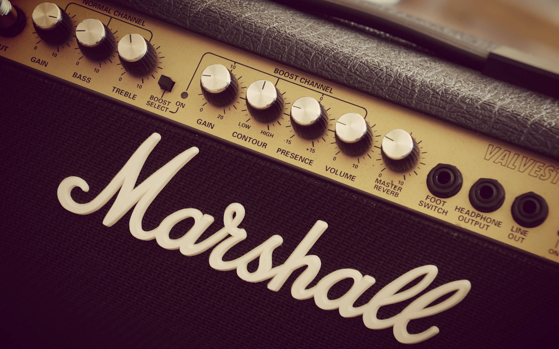 美學風格馬歇爾吉他擴大機 壁紙 — 特寫鏡頭：復古 Marshall 結他擴音器，配以奶油色旋鈕和黑色網布，在溫暖燈光下。