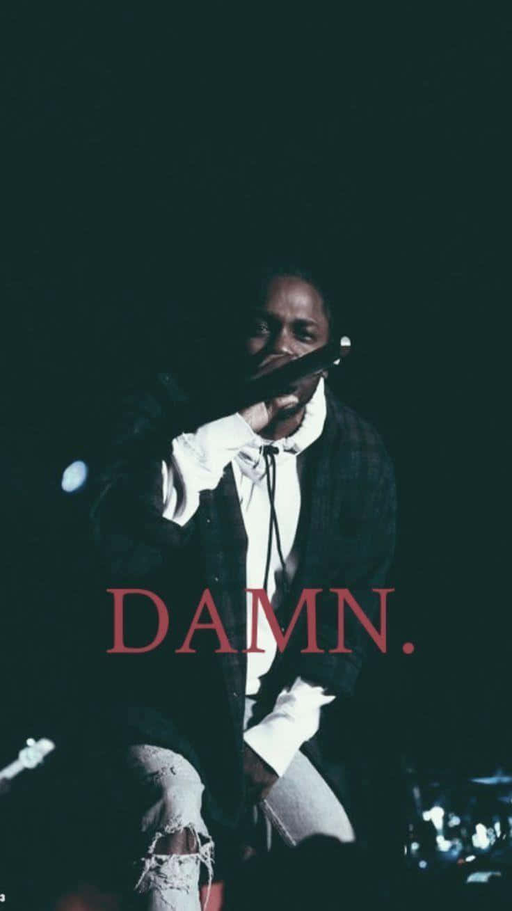 Kendrick Lamar 在舞台上表演，帶有紅色 DAMN 文字疊加。