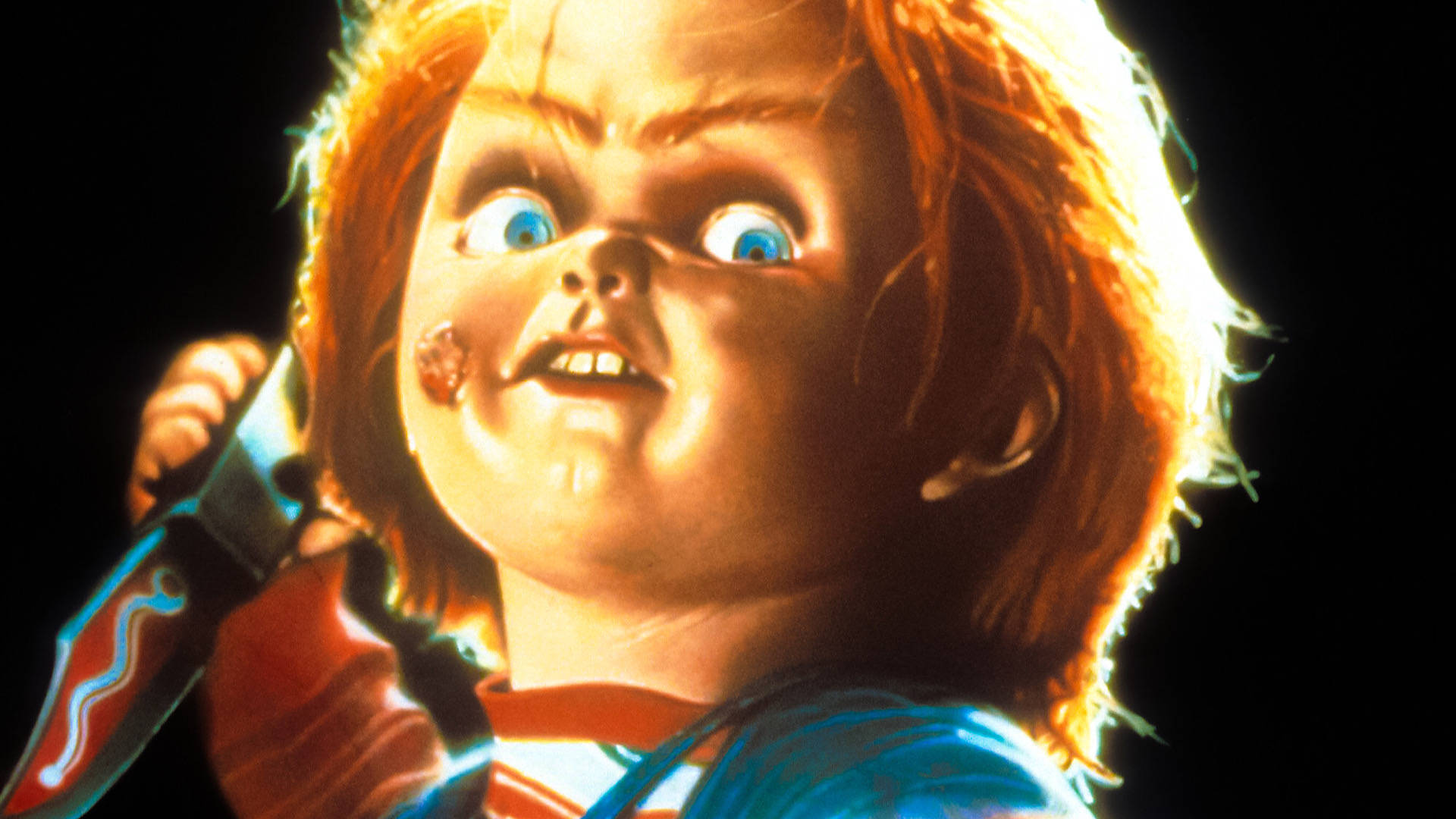 恐怖娃娃 Chucky 手持刀，滿臉鮮血，眼睛睜大。