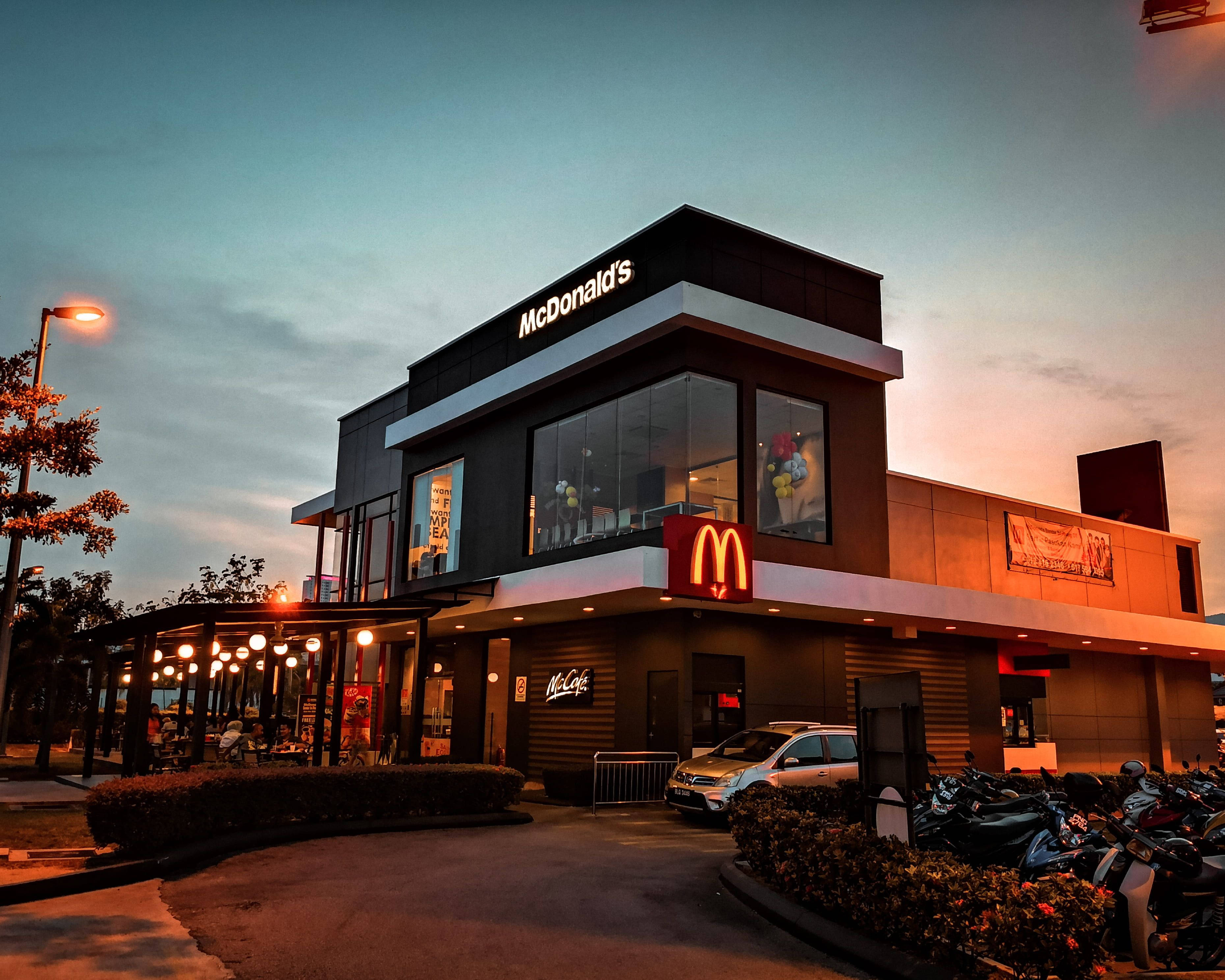 美學麥當勞店鋪 壁紙 — 一間現代化的麥當勞餐廳在黃昏時亮起溫暖的燈光，映照著暮色天空。