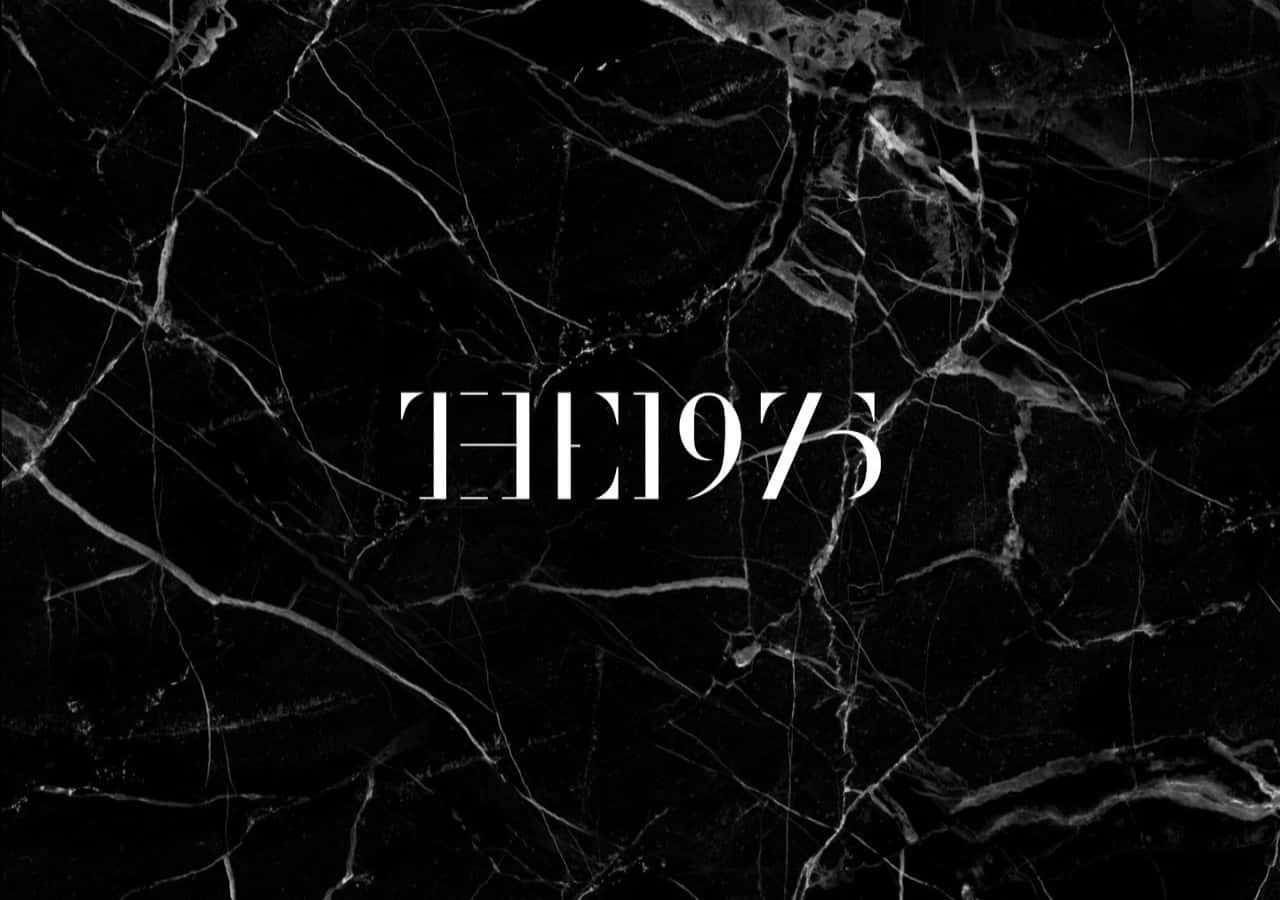 美學龐克桌面 The 1975 壁紙 — 粗體白色文字「THE1975」印在帶有複雜灰色紋理的時尚黑色大理石背景上。
