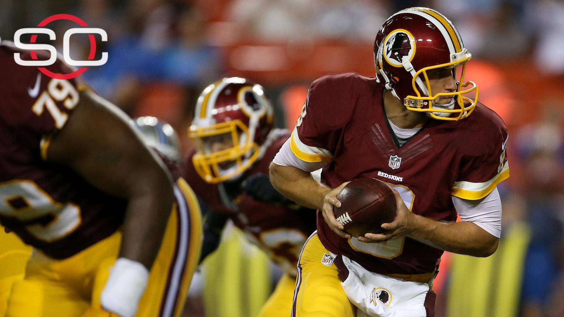 美式足球員 Kirk Cousins 壁紙 — 華盛頓紅皮隊的四分衛身穿栗色和金色球衣，在夜間比賽中持球進行中。