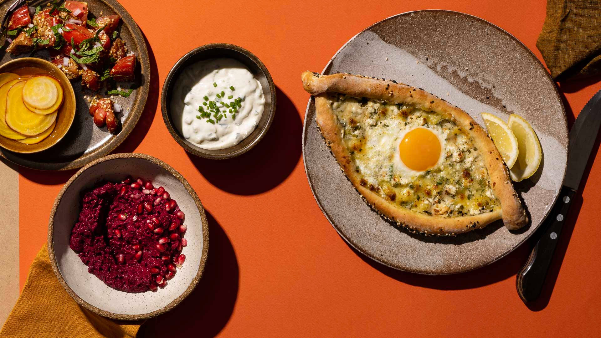 色彩繽紛的早餐菜餚，包括雞蛋薄餅、石榴和乳酪。