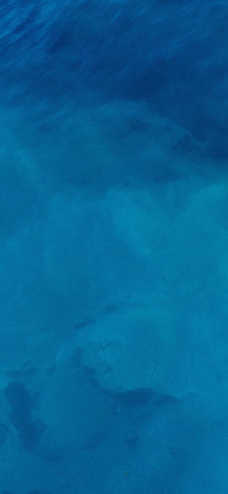 藍色海水的航拍視圖，顯示沙質海床圖案。