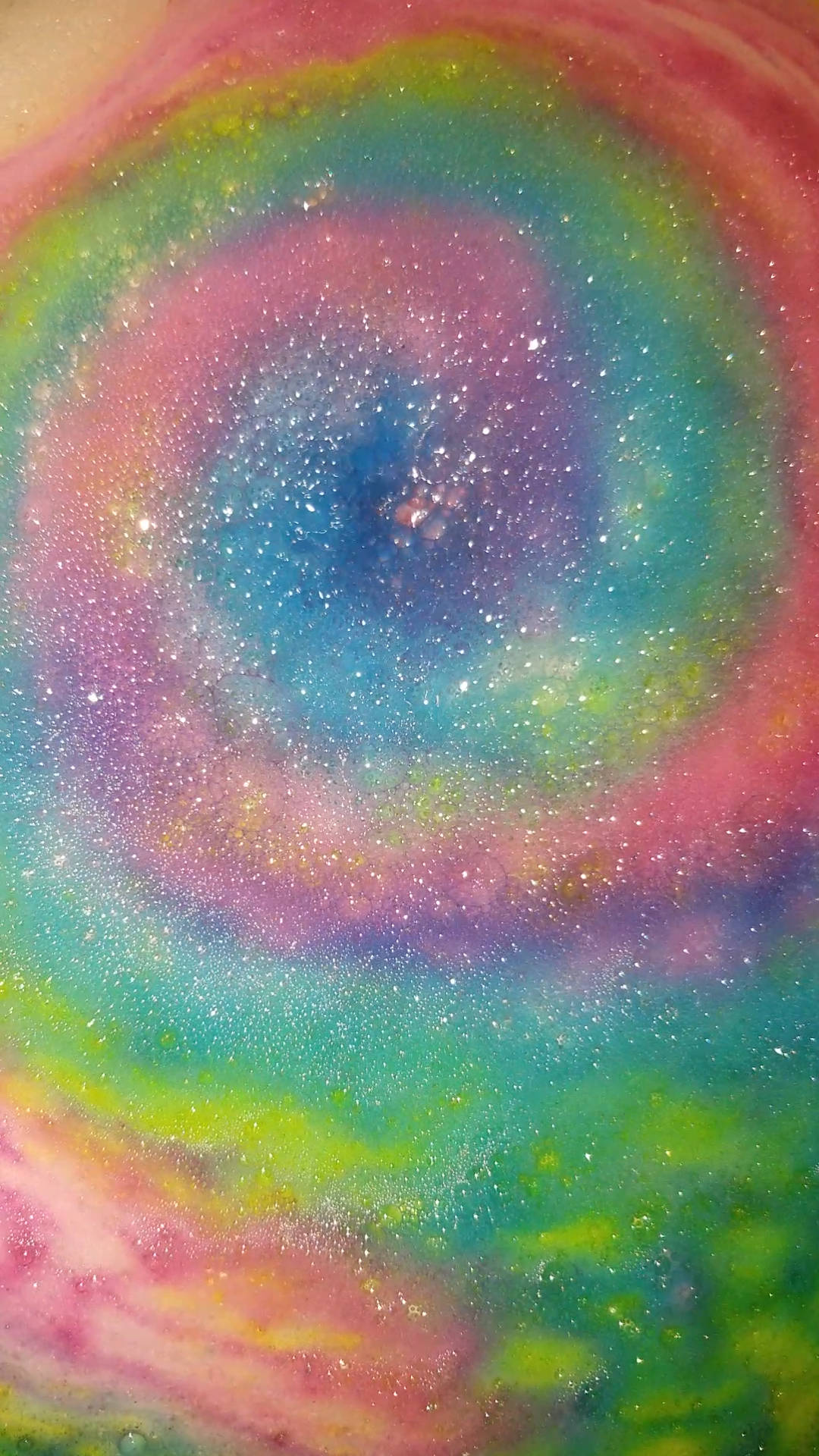 美麗彩虹漩渦鎖屏壁紙 壁紙 — 一個閃爍粉彩顏色的旋轉星系從宇宙中心向外輻射，形成迷人的抽象圖案。