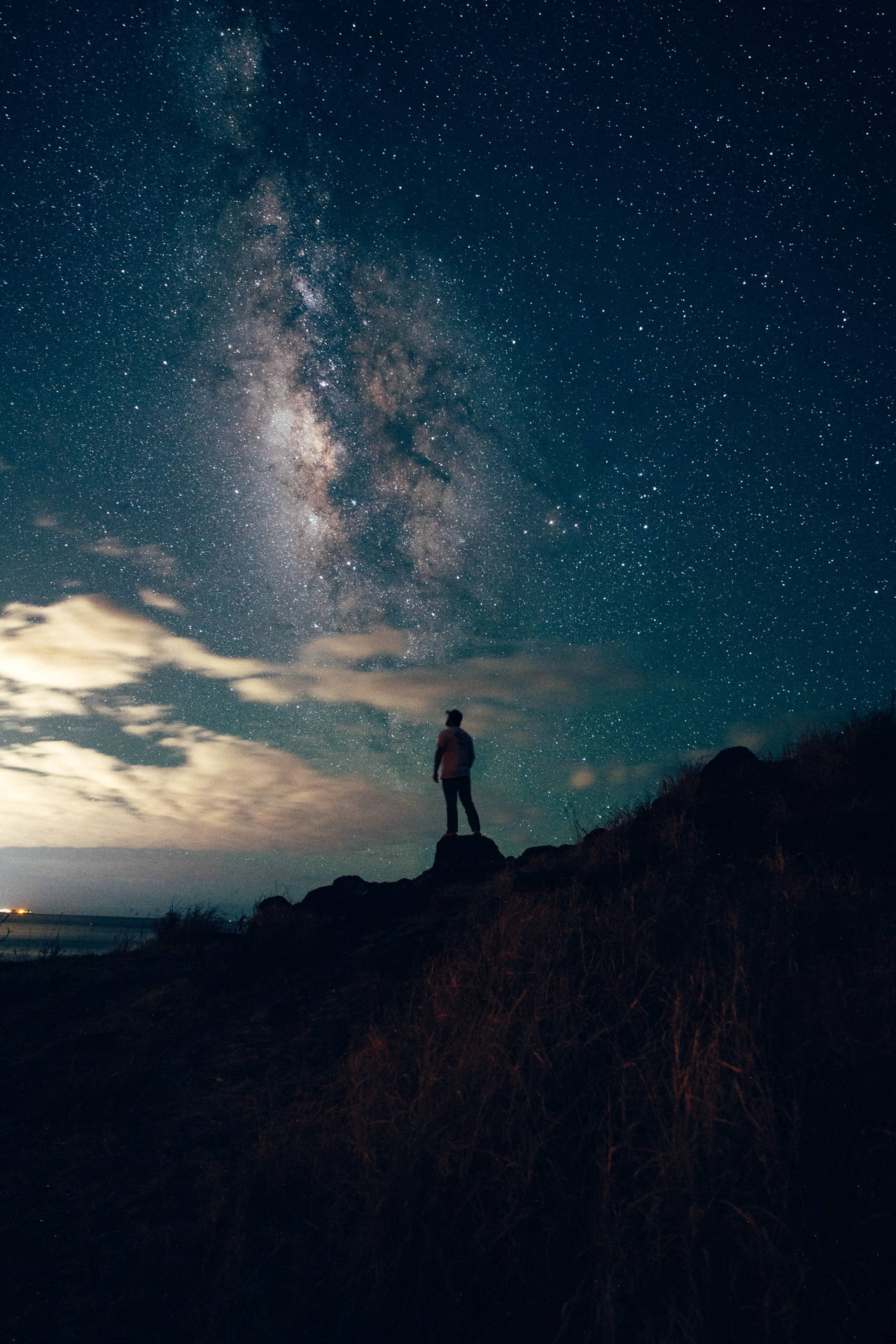 夜晚站在山上觀看星星和銀河的人
